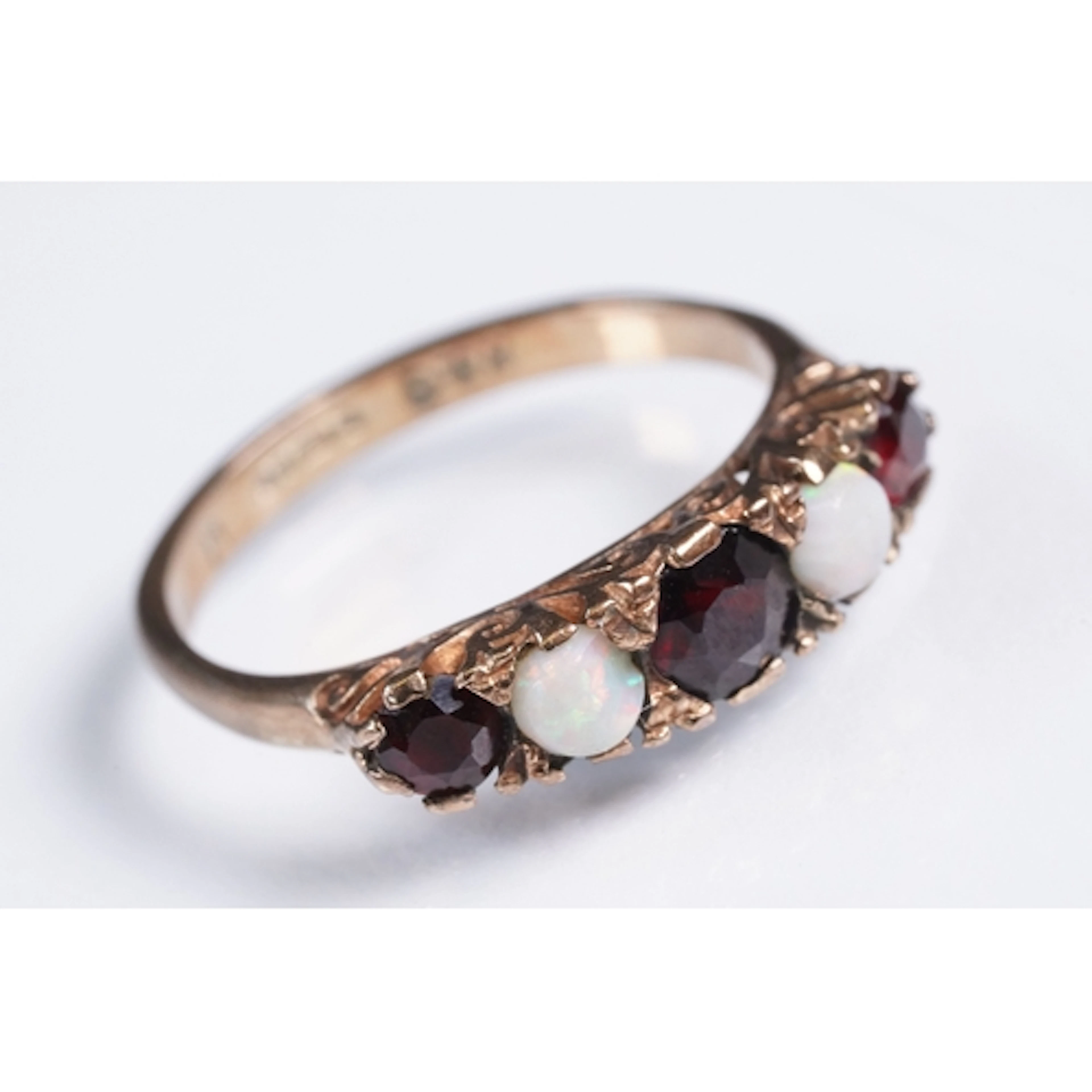 9ct gold, garnet and opal five stone ring. The ring being se...