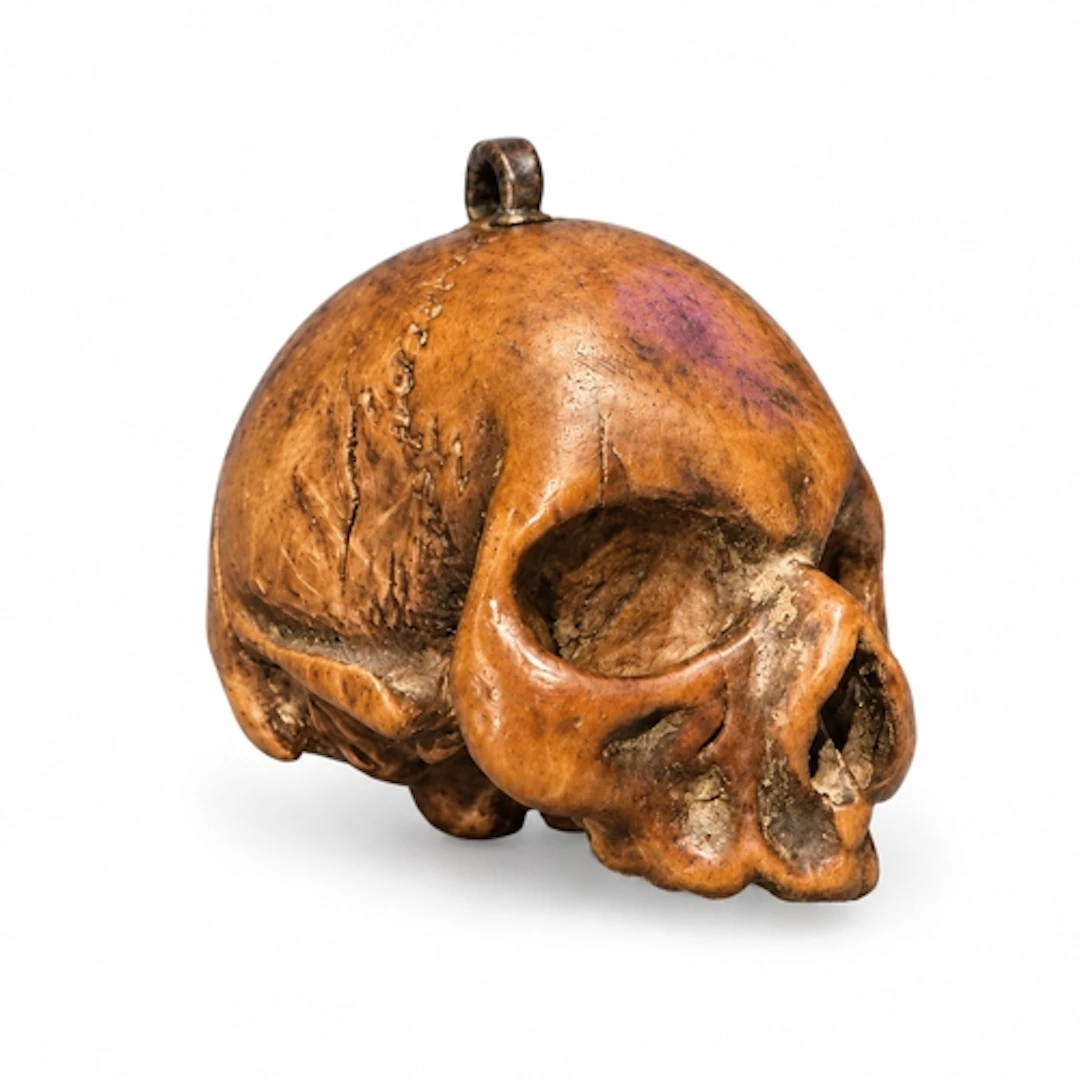 A finely carved boxwood pendant bead in the form of a human ...