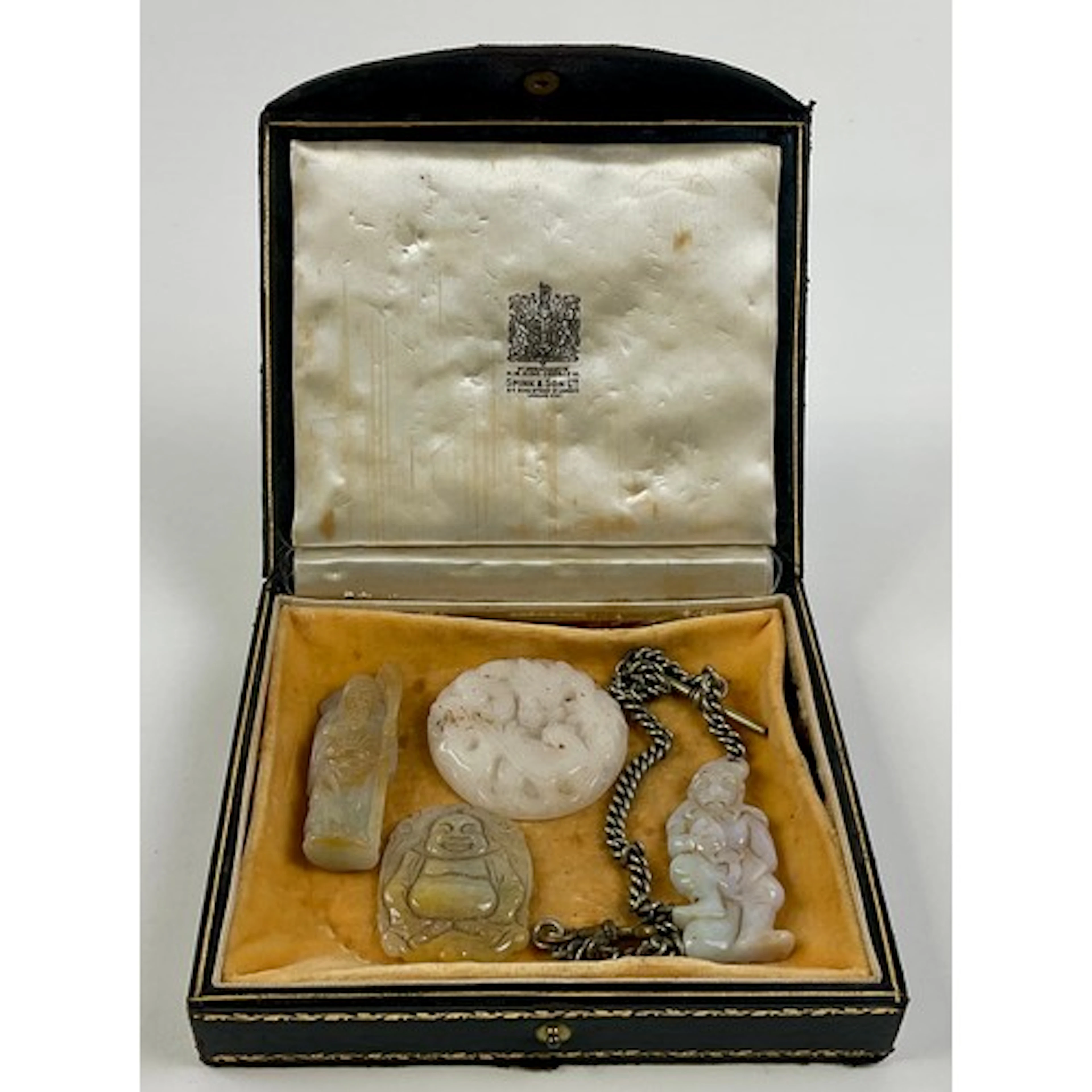 A Chinese jade pendant, carved as a monkey holding a peach, ...
