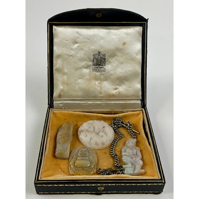 A Chinese jade pendant, carved as a monkey holding a peach, ...
