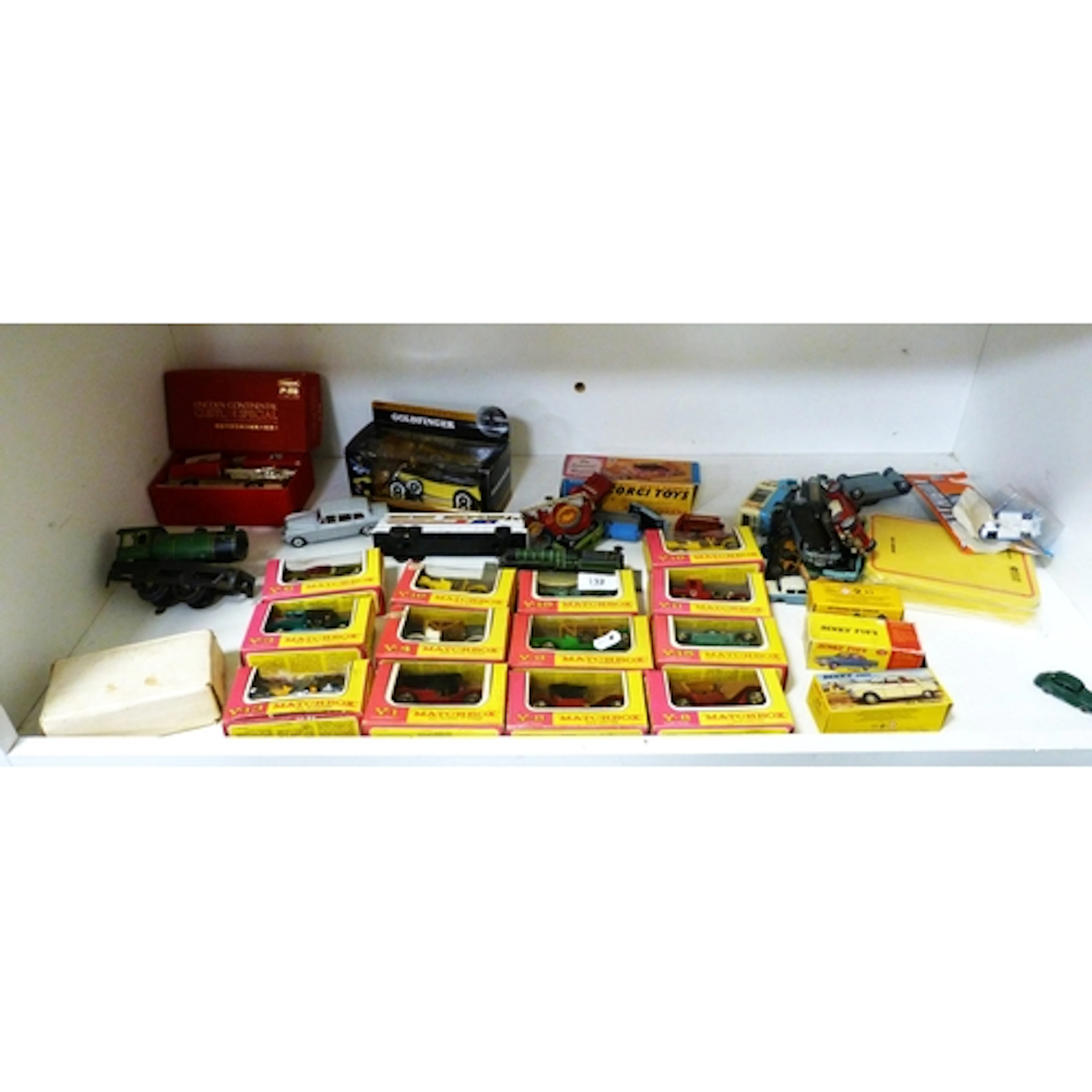 Shelf containing assorted boxed and playworn die-cast model ...