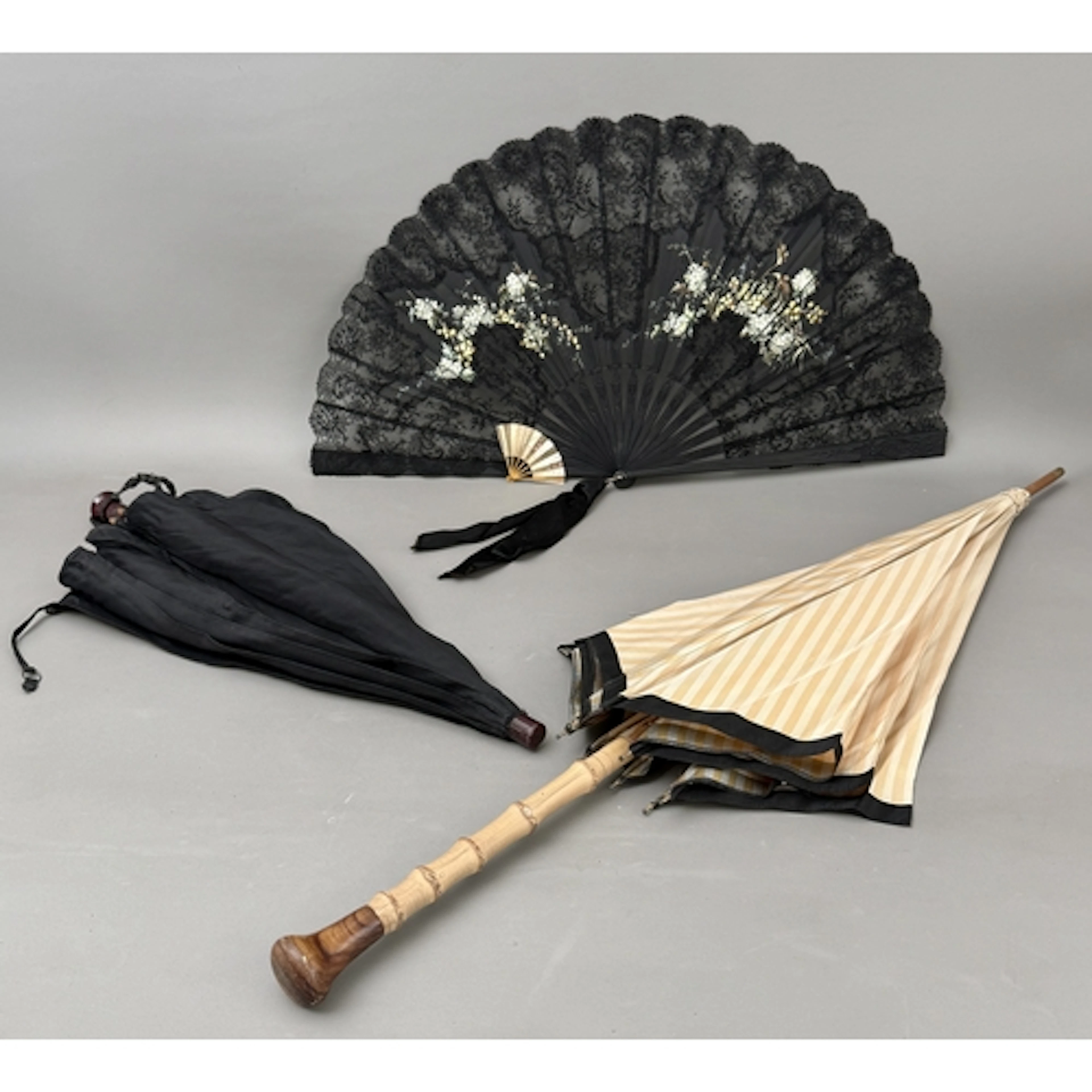 A black gauze and lace floral decorated fan - with black car...