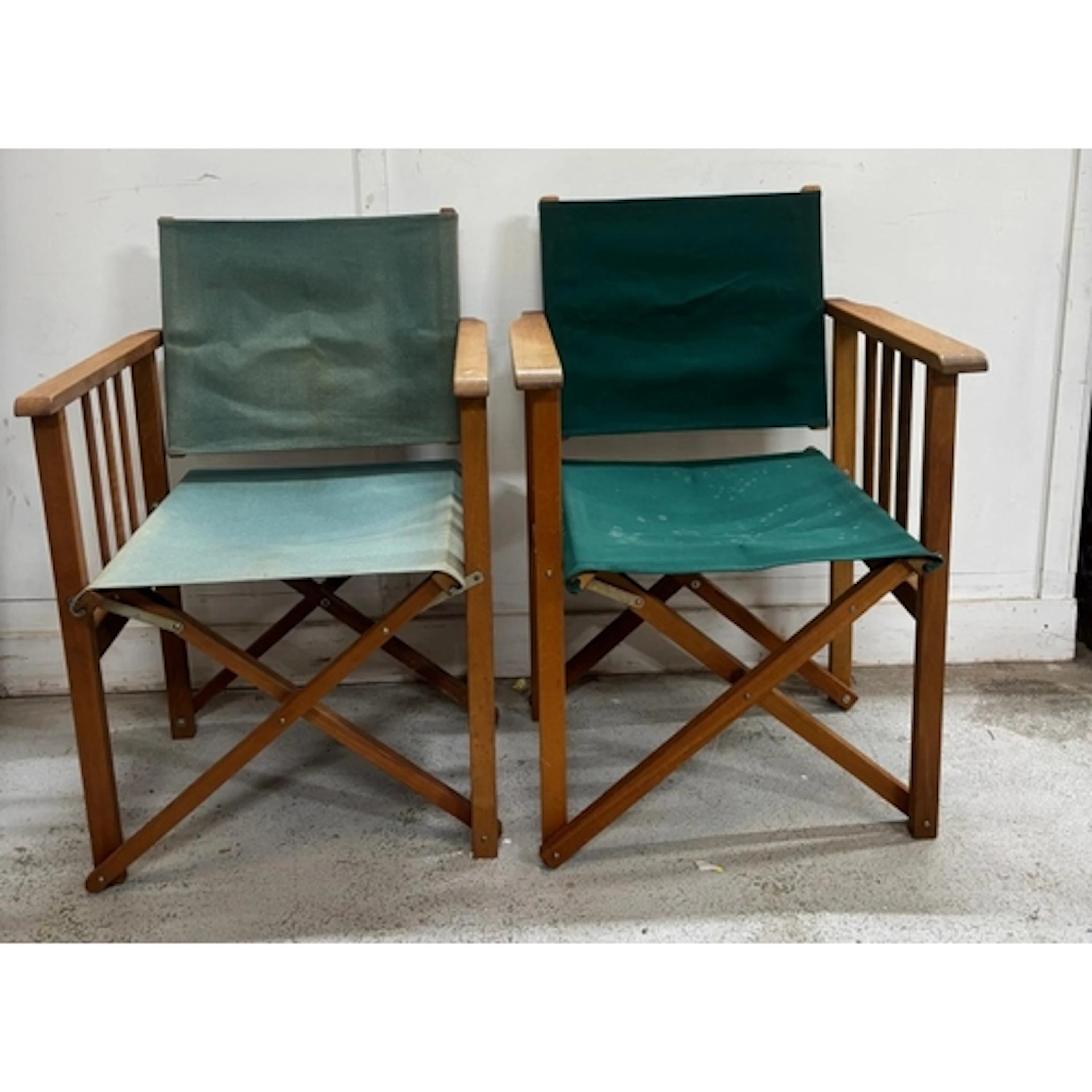 Two classic folding director's chairs featuring green canvas...