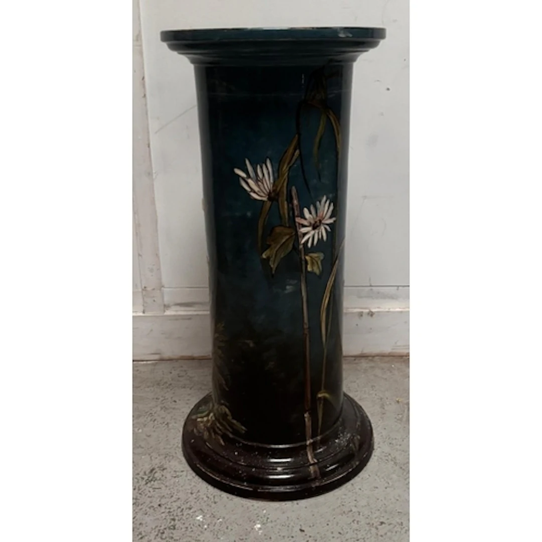 A dark blue ceramic pedestal plant stand with floral motif...
