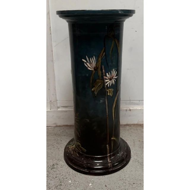 A dark blue ceramic pedestal plant stand with floral motif...