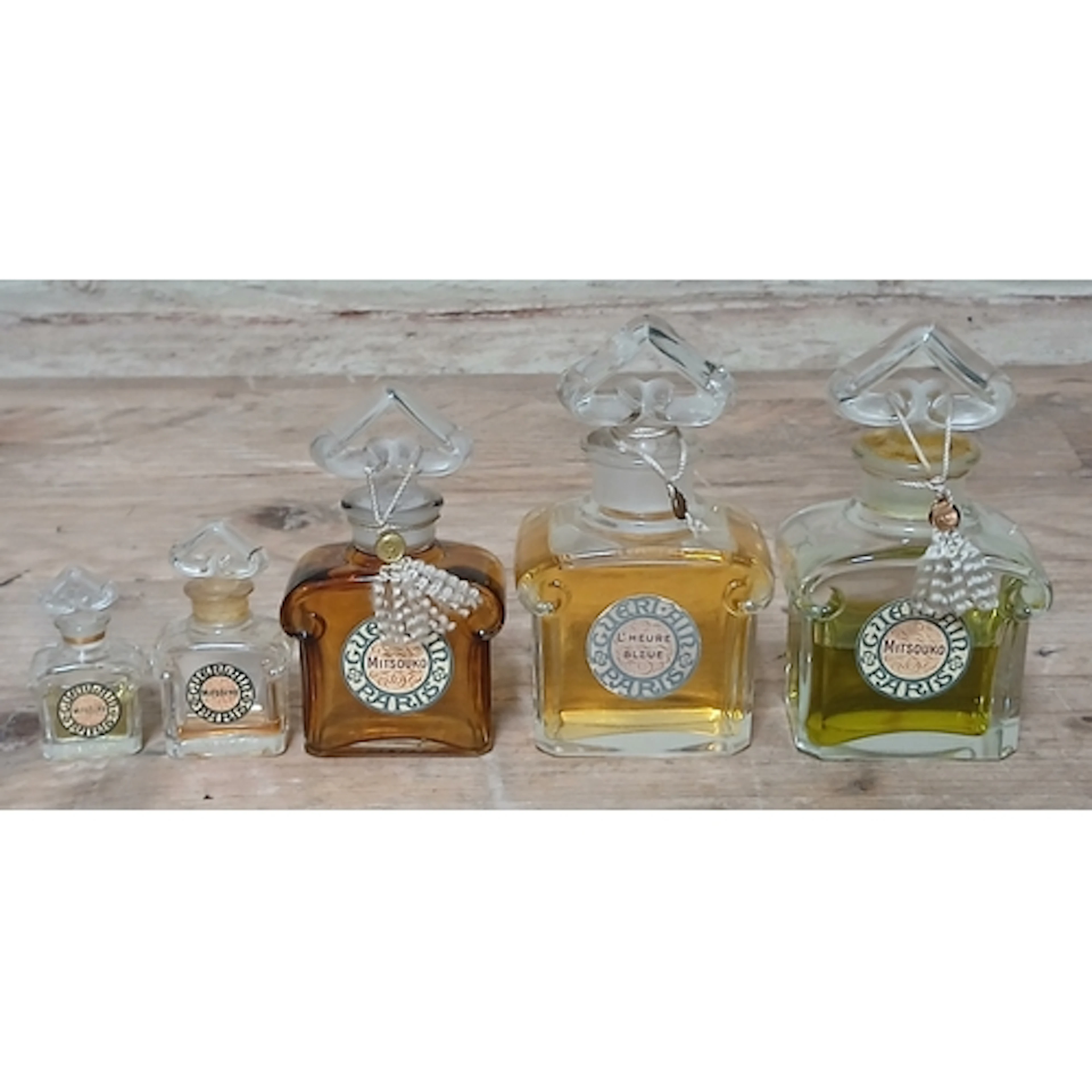 Guerlain, a group of five graduated perfume bottles and cont...