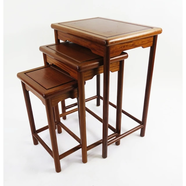A Chinese mahogany nest of three tables raised on turned leg...