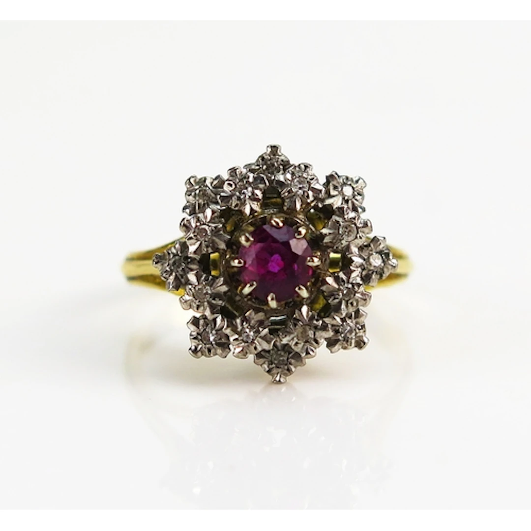 A ruby and diamond cluster ring in an 18ct yellow gold setti...