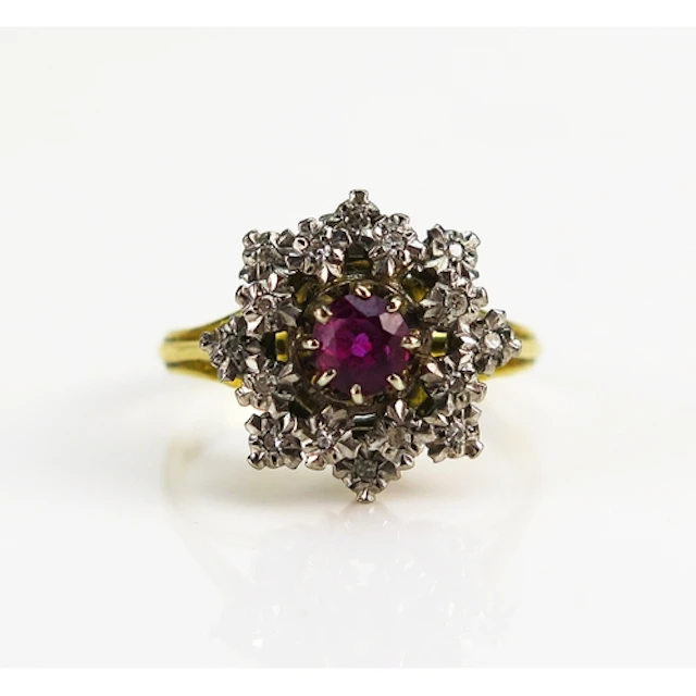 A ruby and diamond cluster ring in an 18ct yellow gold setti...