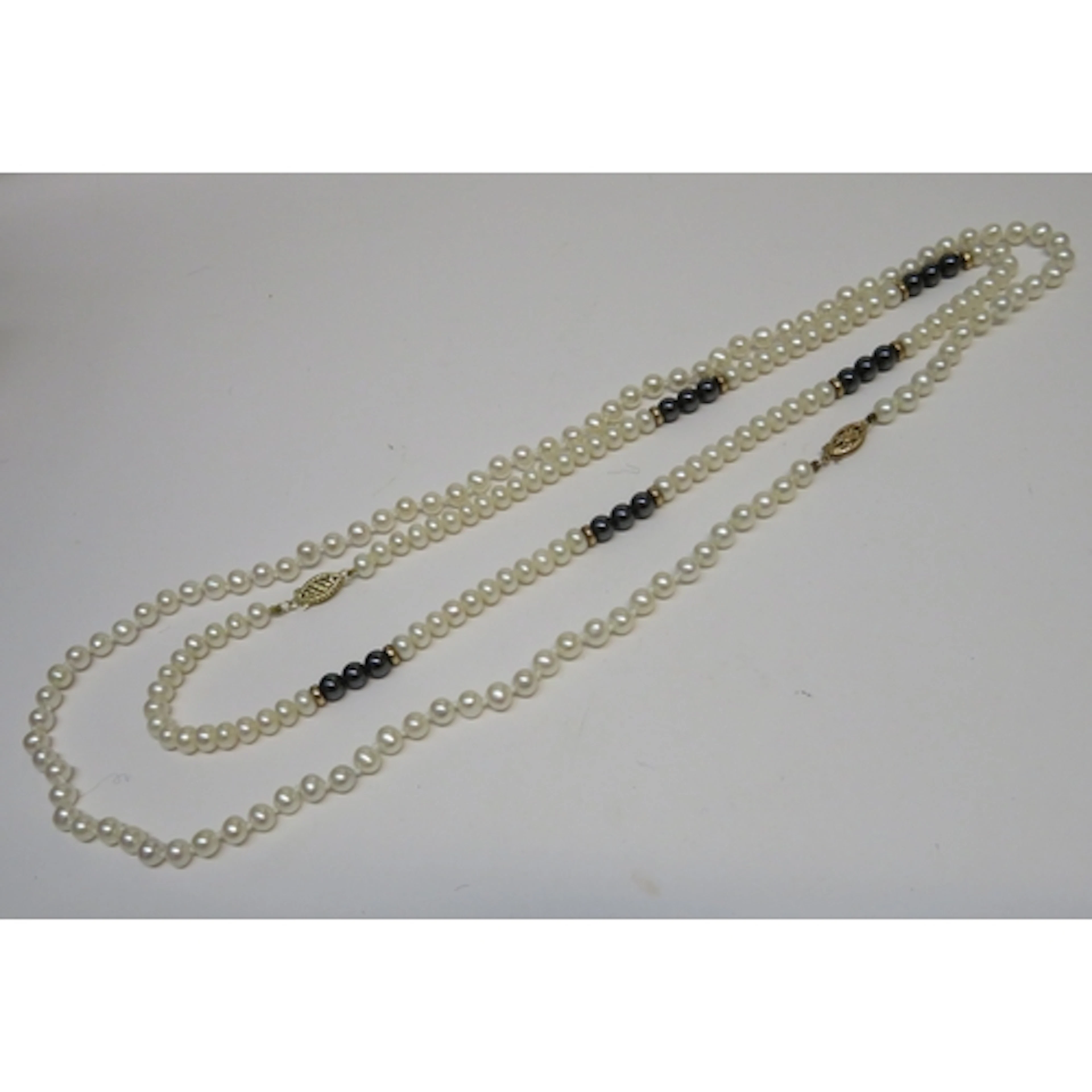 Pair of cultured pearl necklaces, one with 9ct gold clasp, t...