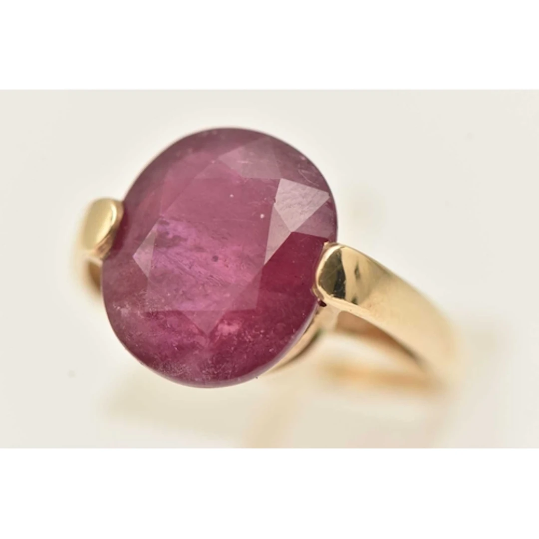 A 9CT GOLD GLASS FILLED CORUNDUM RING, large oval cut corund...