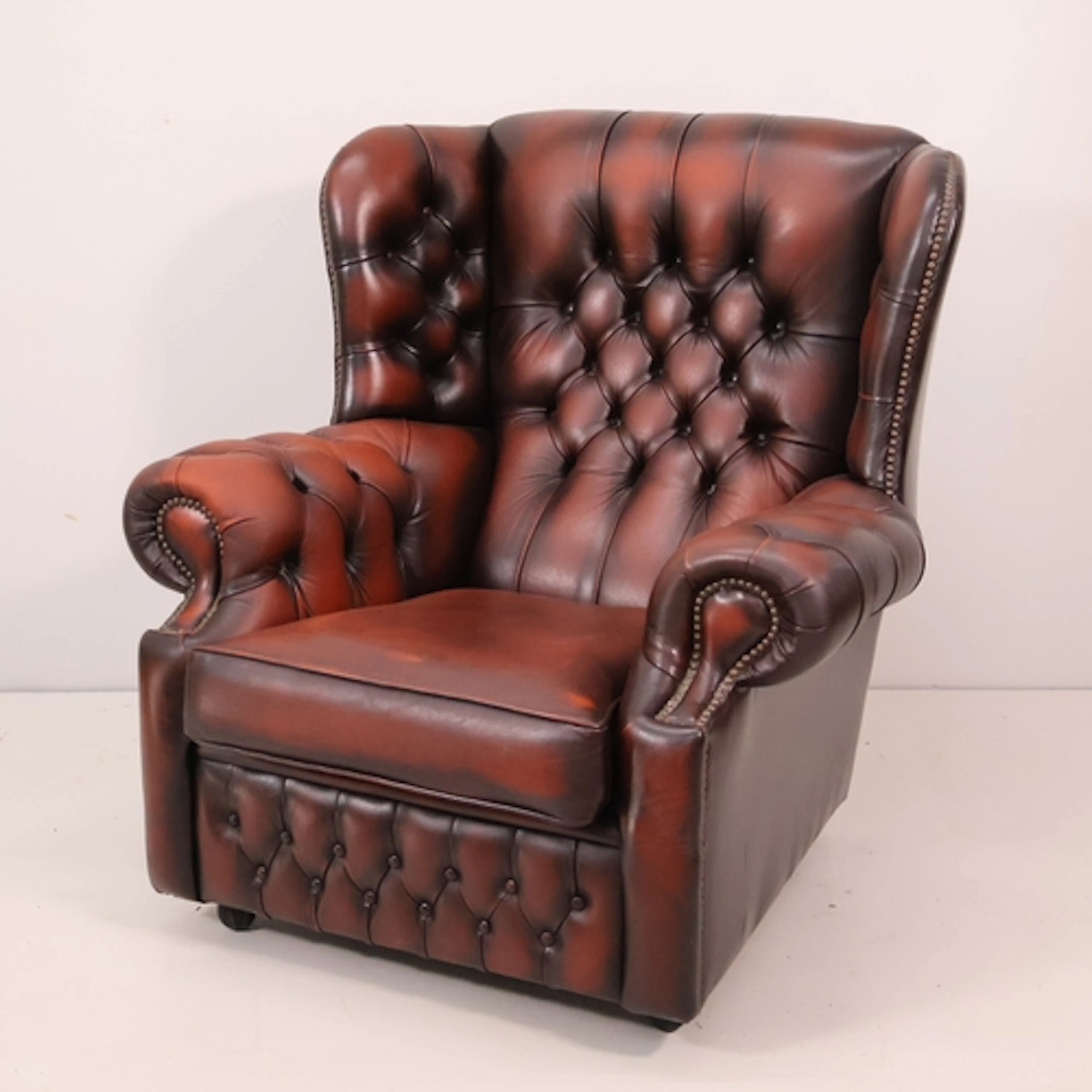 A oxblood leather upholstered Chesterfield style wingback fi...