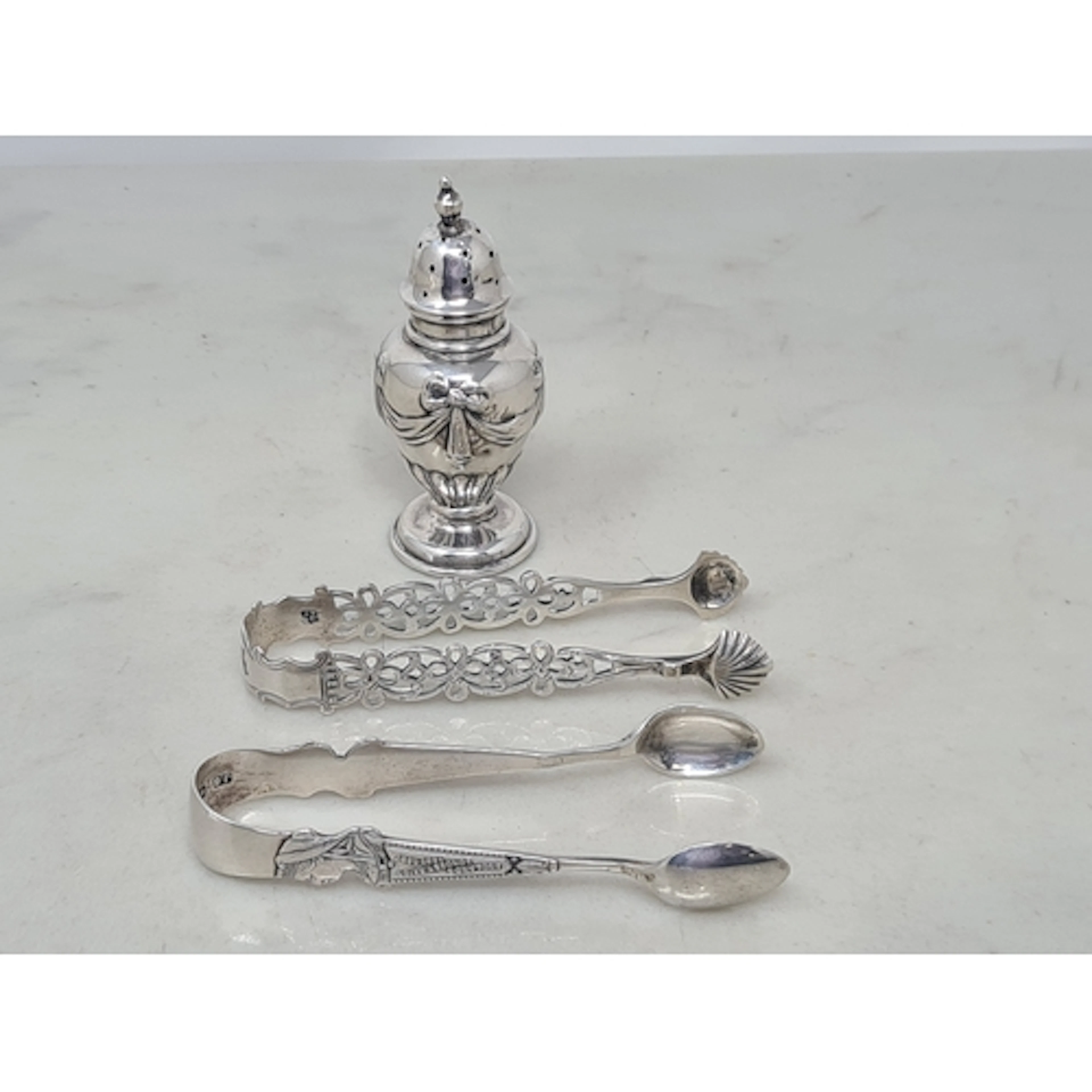 An Edward VII silver Pepperette with ribbon and swag embossi...