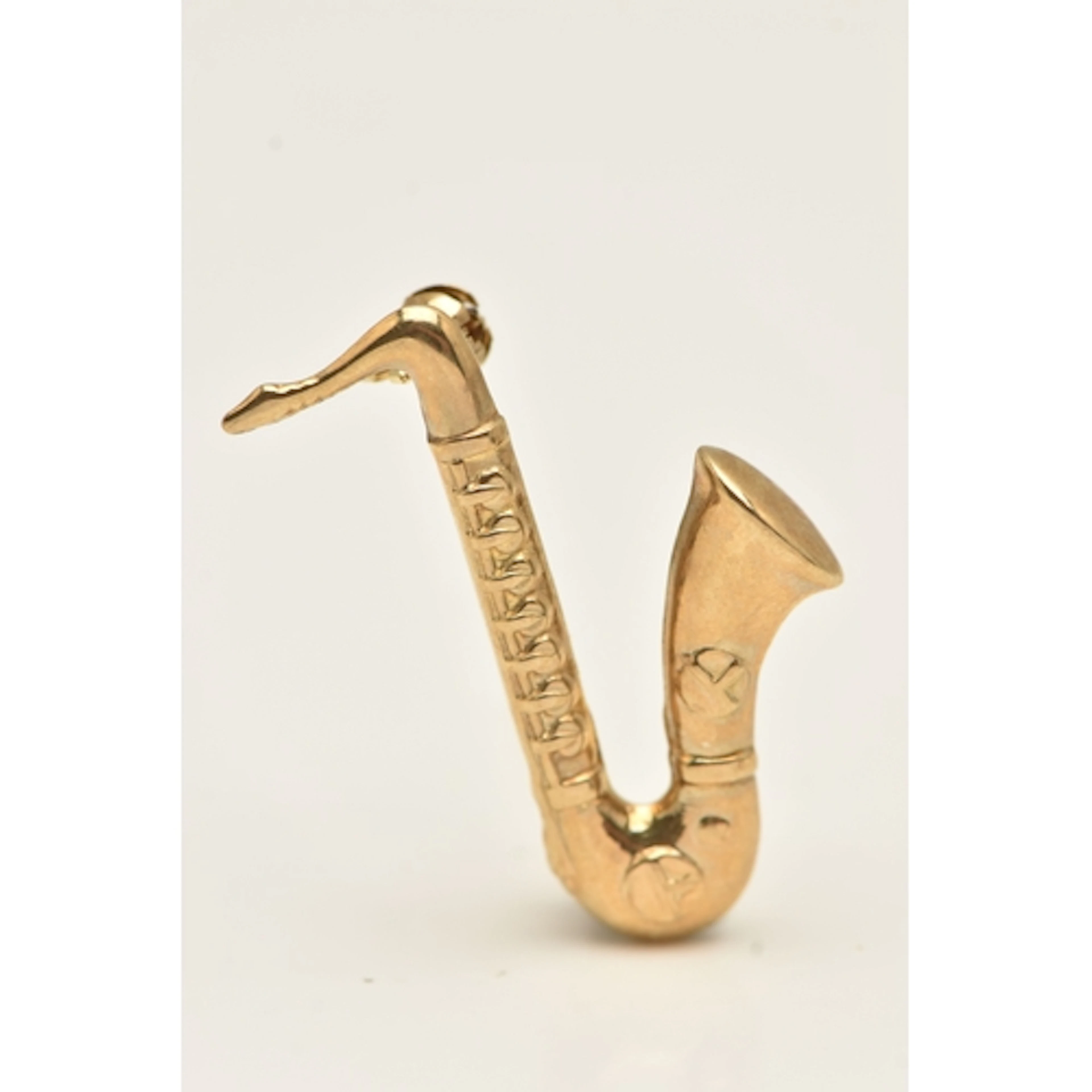 A YELLOW METAL SAXOPHONE BROOCH, hollow form saxophone, fitt...