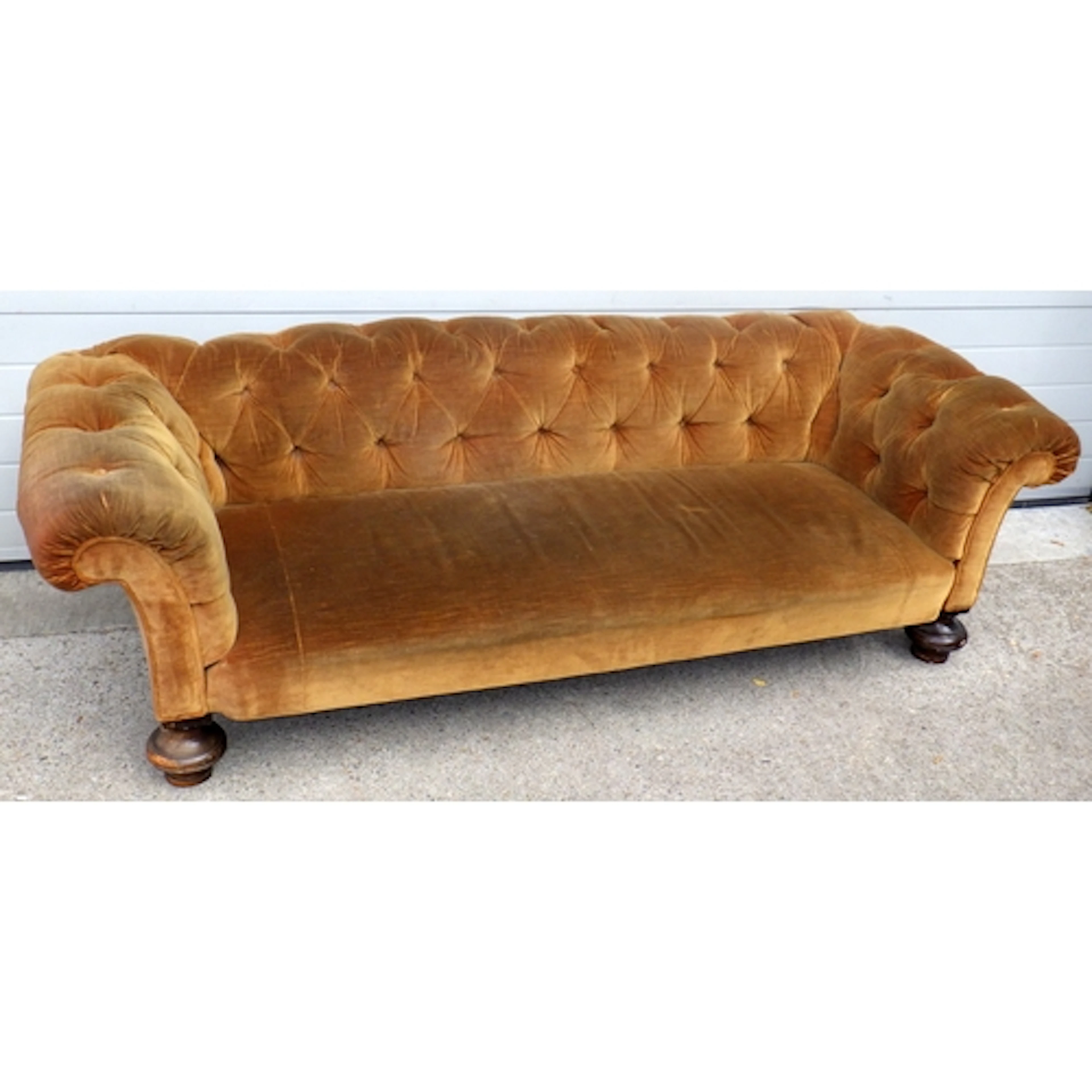 A Victorian button upholstered Chesterfield sofa on bun feet...