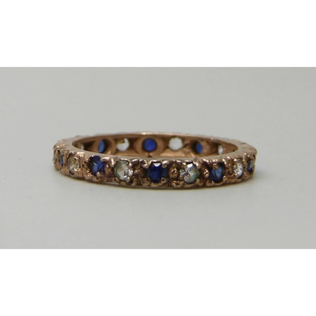 A 9ct gold, sapphire and white stone eternity ring, 2.2g, O
