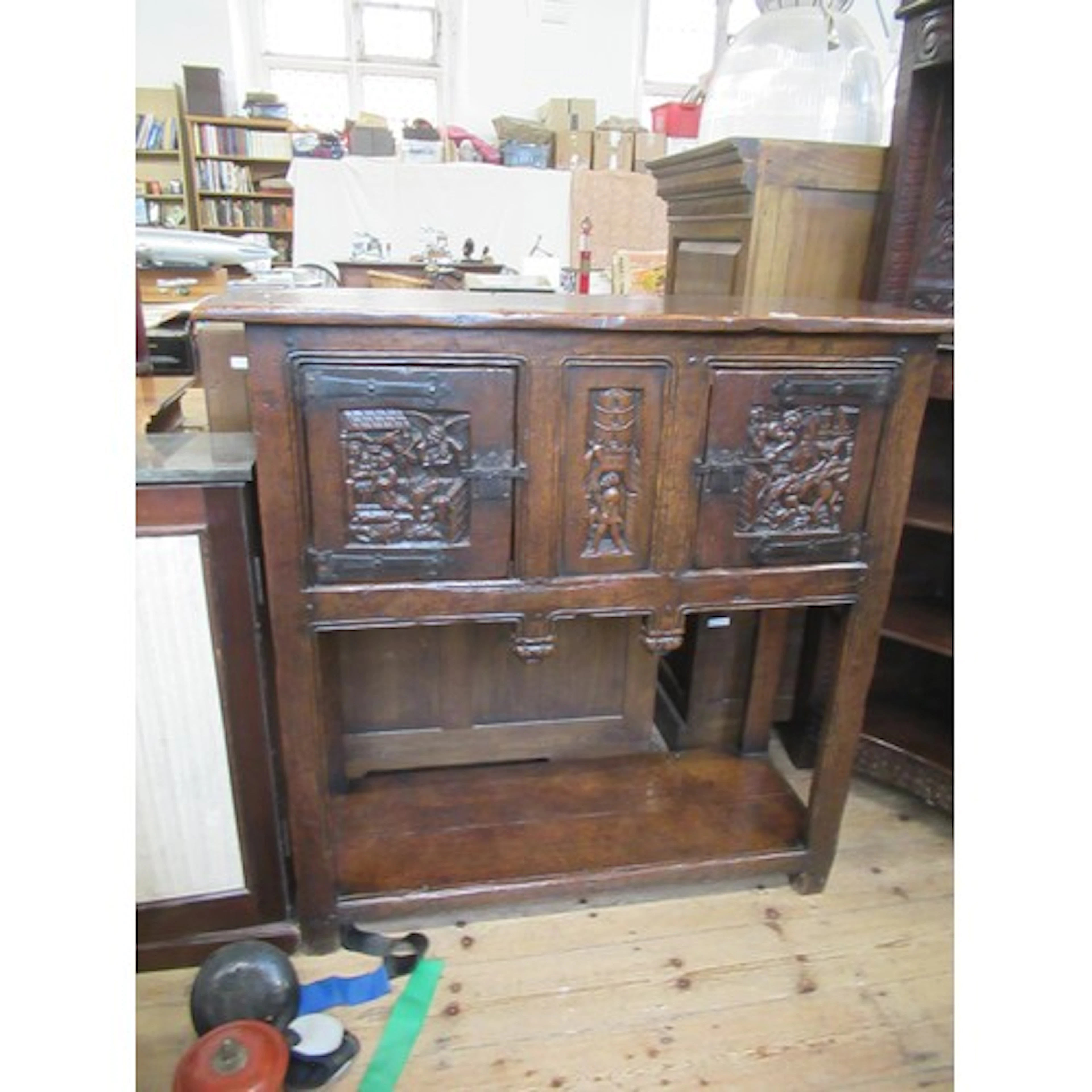 An antique style oak cabinet the fielded panels decorated w...