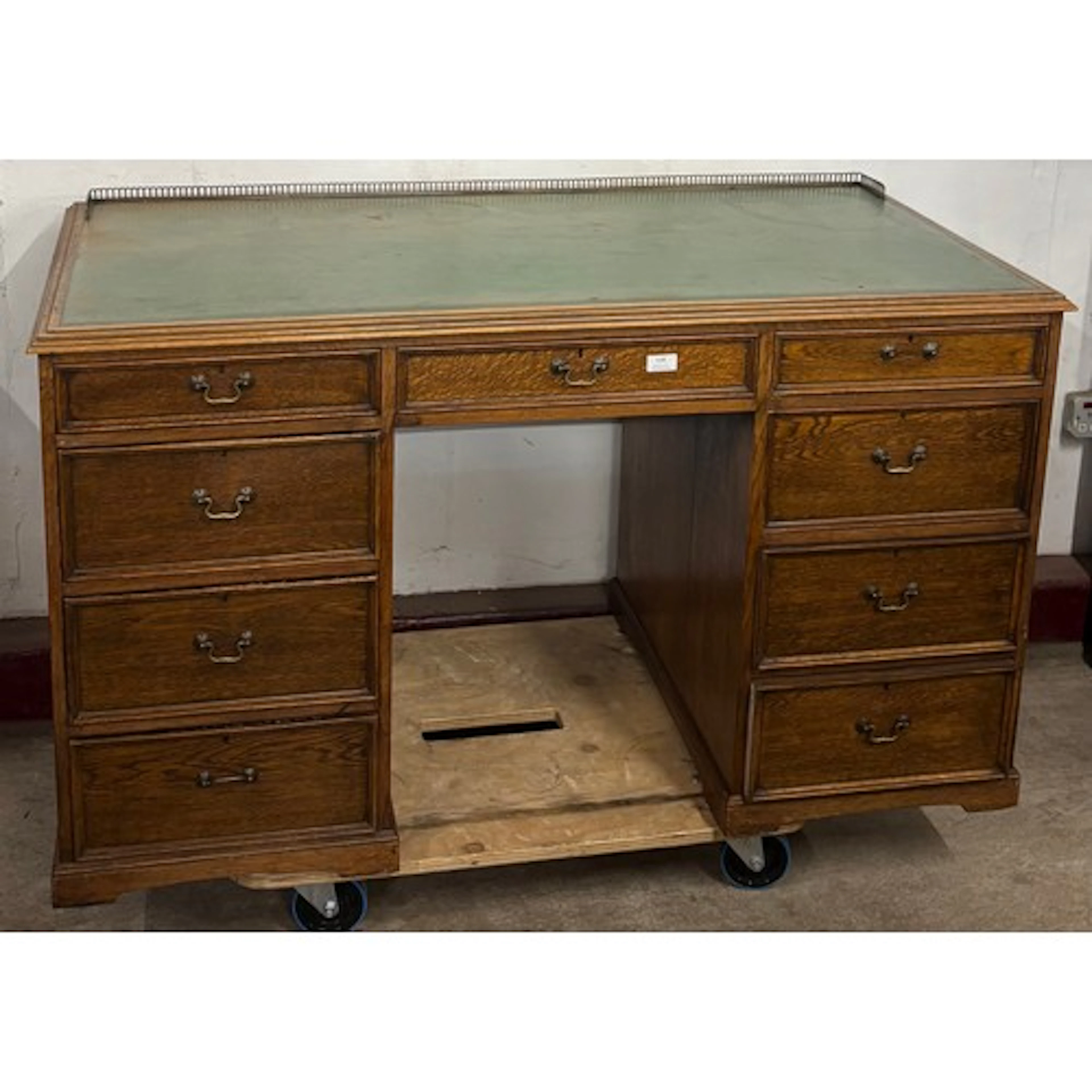 An Edward VII oak and green leather topped library desk