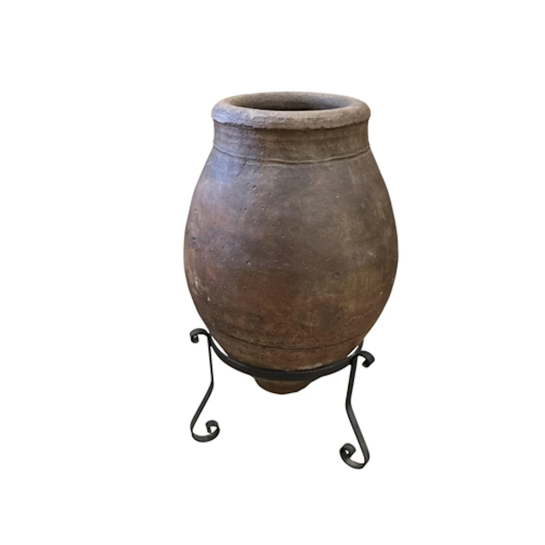 A large Spanish terracotta oil jar, on wrought iron stand, h...