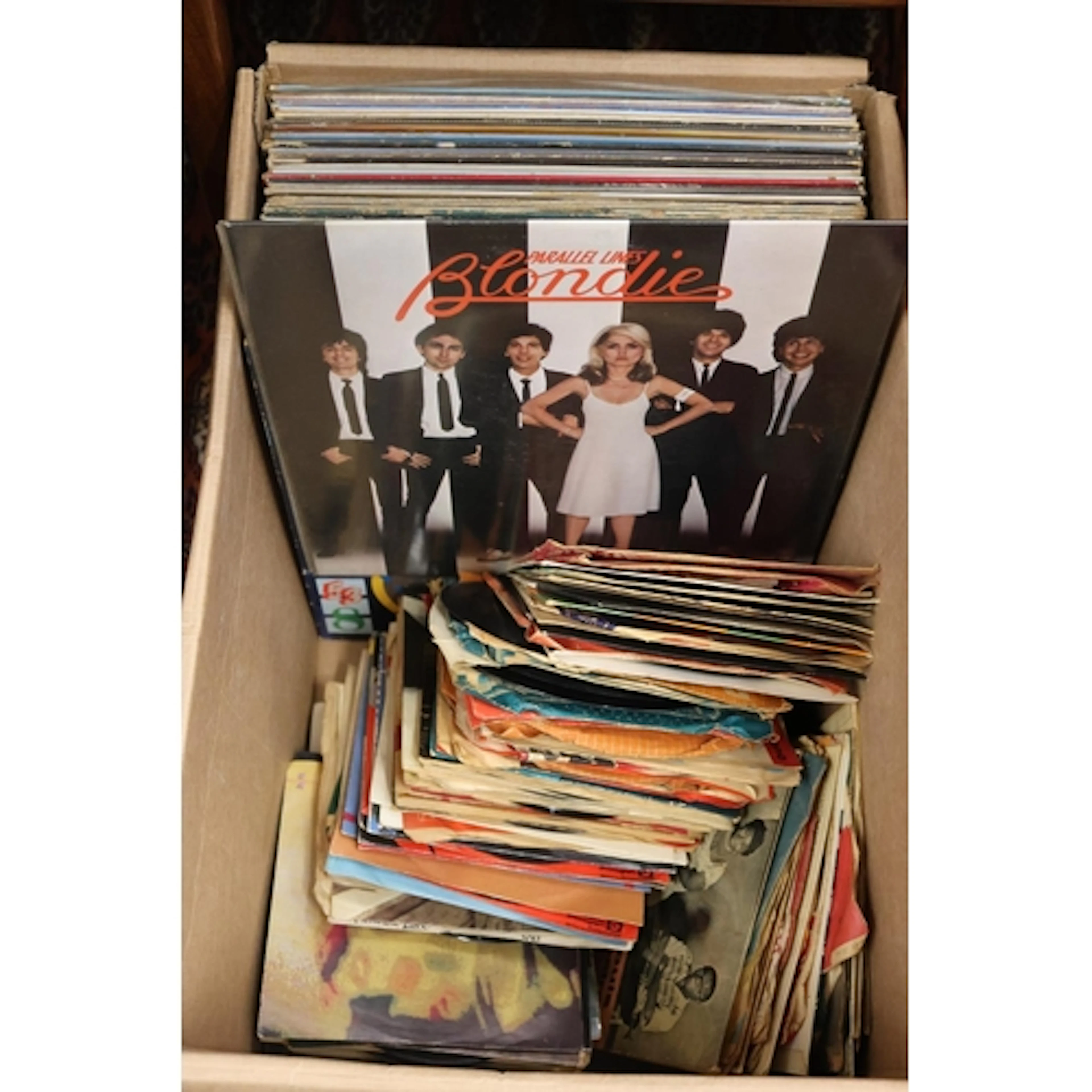 Box containing a mix of vinyl records and singles to include...