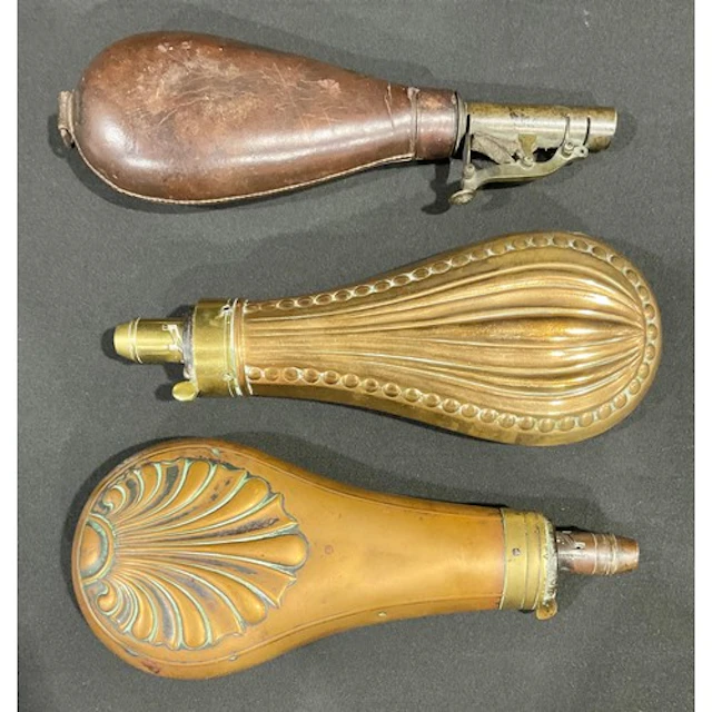 A collection of three 19th century powder flasks, two of cop...