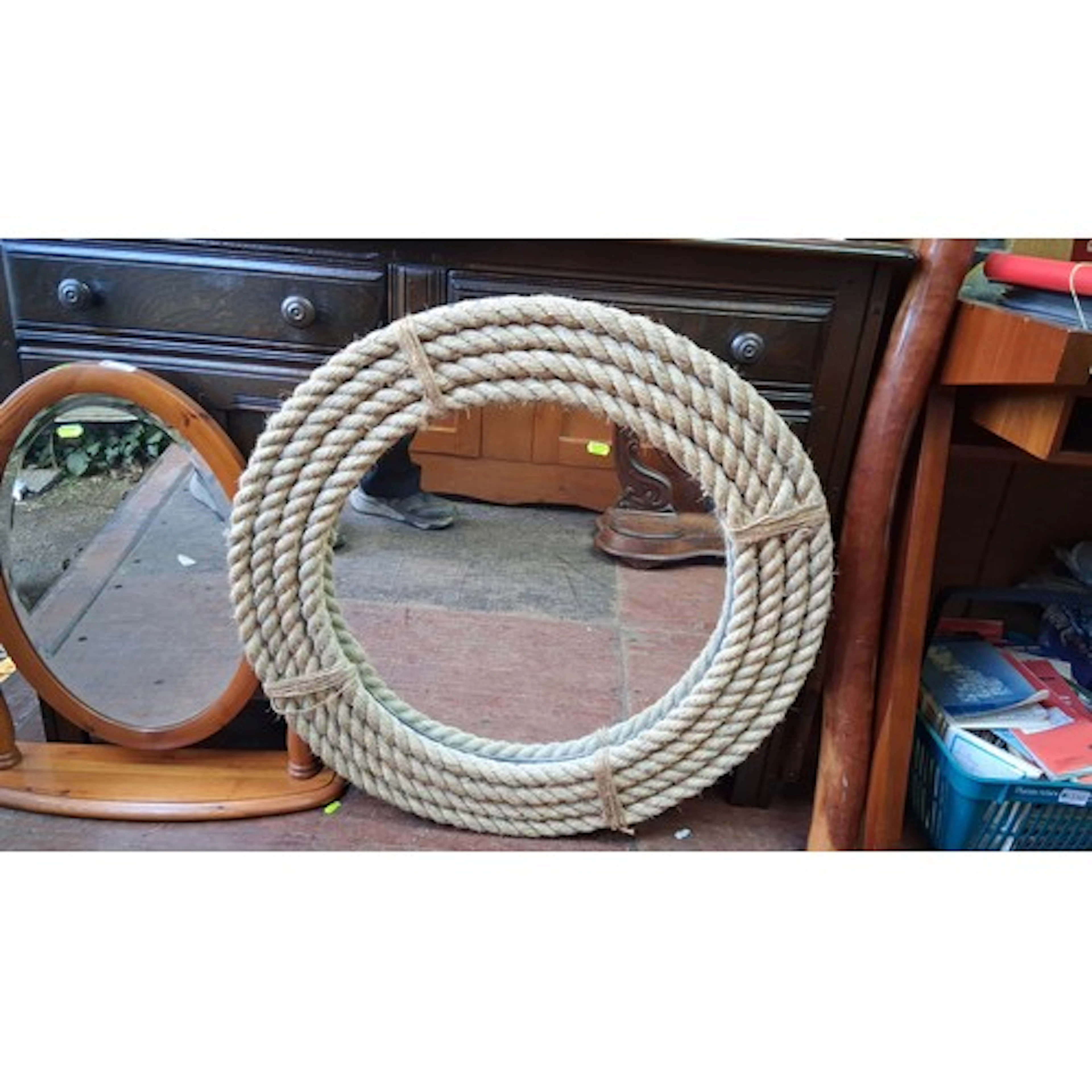 A circular wall mirror with thick braided rope frame