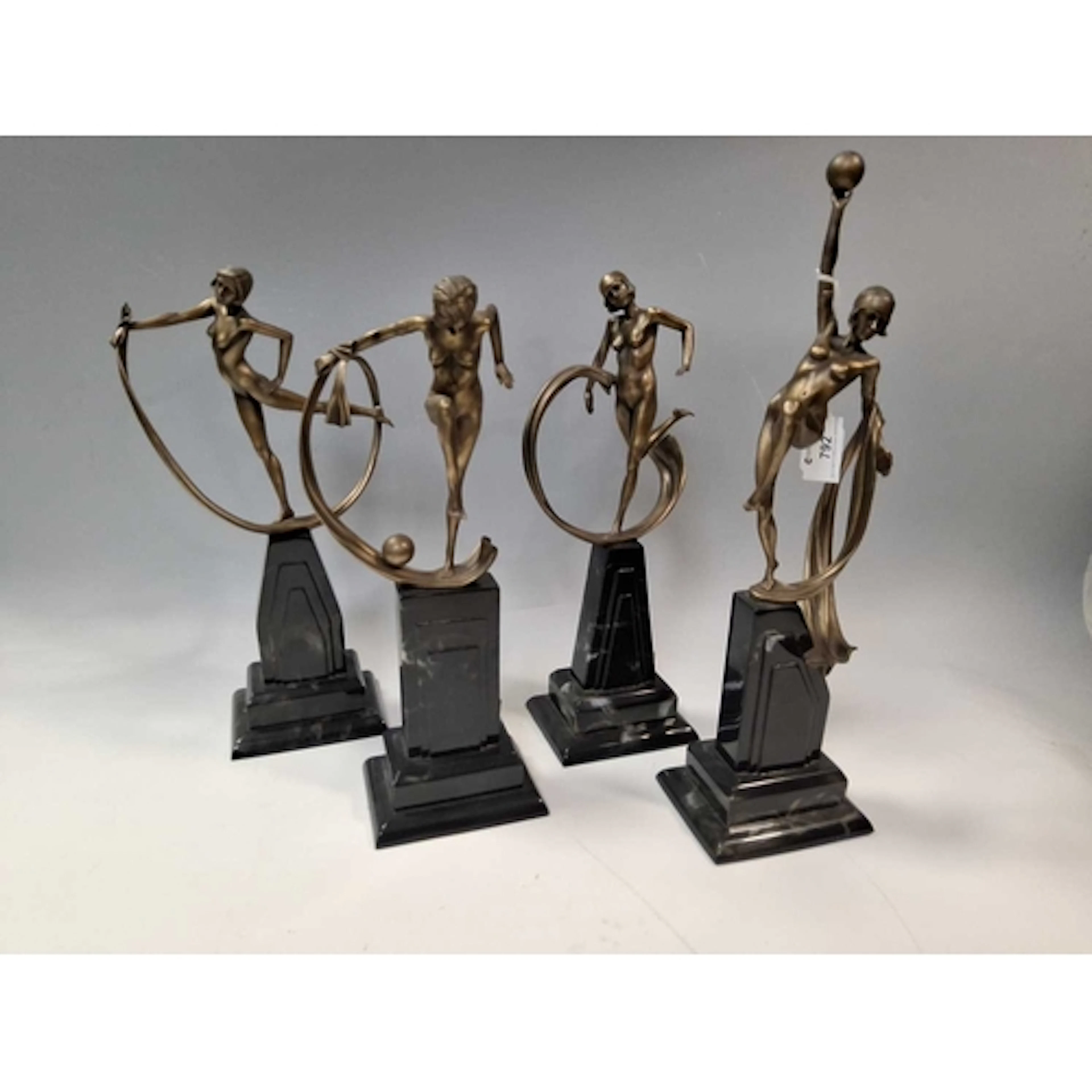 A GROUP OF FOUR COMPOSITE BRONZE EFFECT ART DECO STYLE FIGUR...