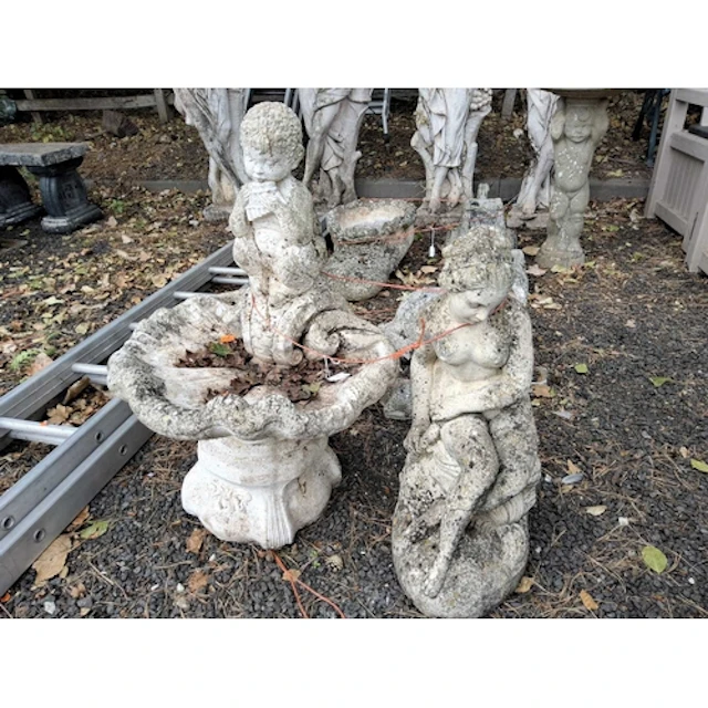 A WEATHERED CONCRETE SHELL SHAPED BIRD BATH, with a small pu...