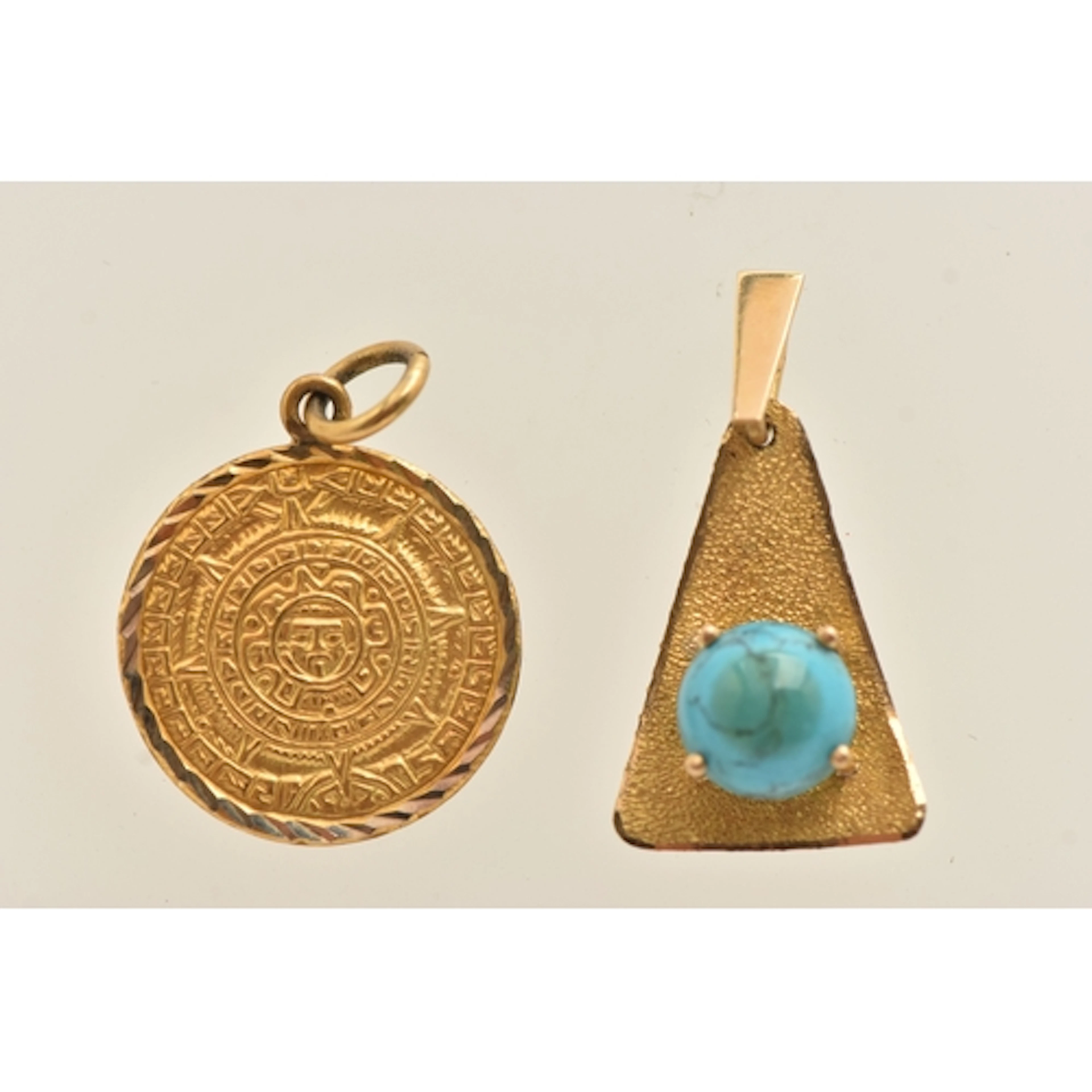 TWO YELLOW METAL PENDANTS, the first a circular form Aztec p...