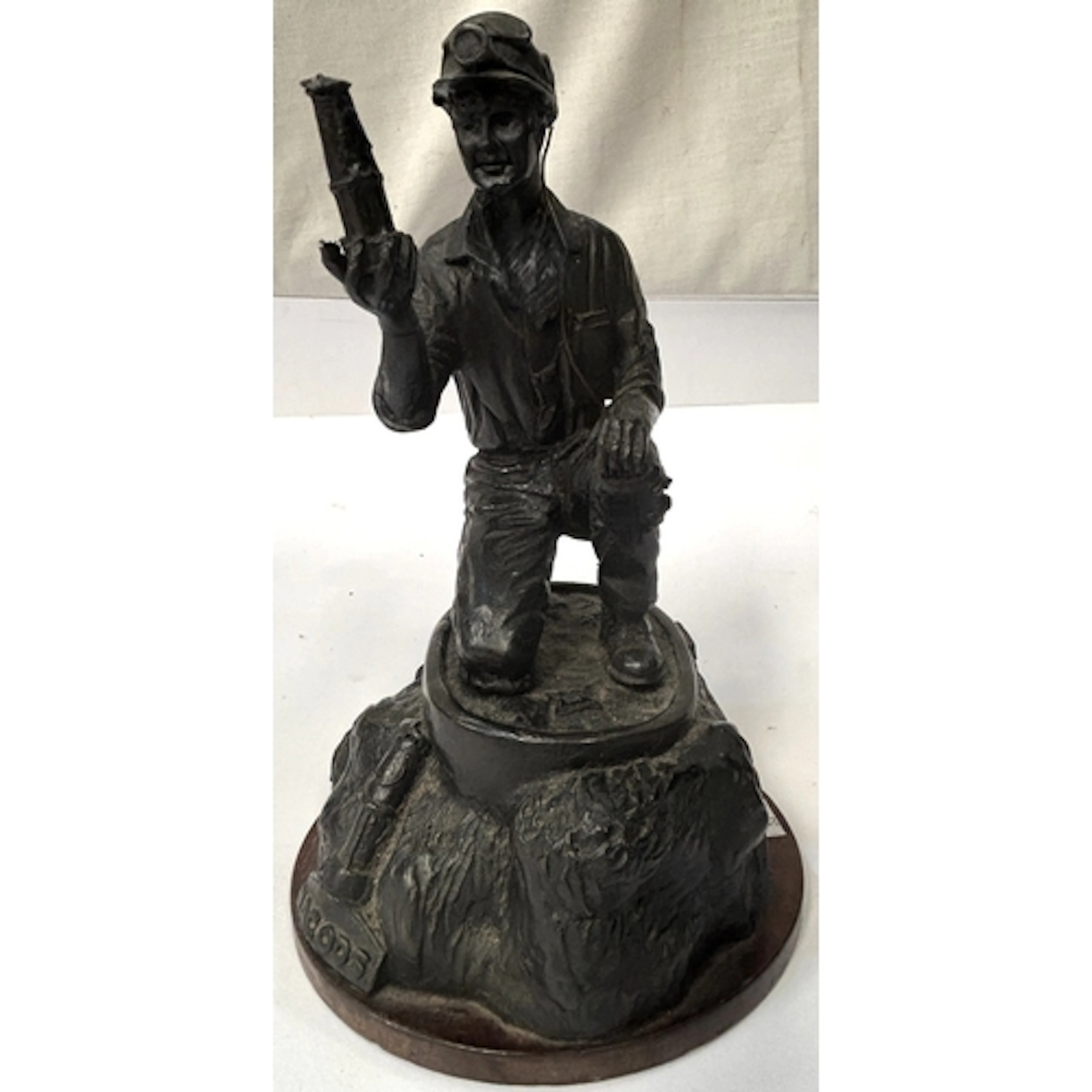 A bronzed commemorative figure of a miner holding a lamp, "N...
