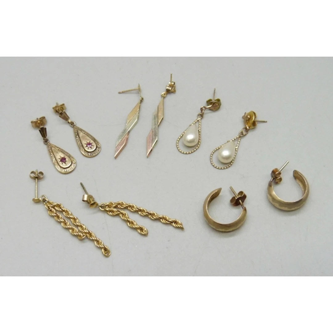 A collection of 9ct gold and yellow metal earrings, some wit...
