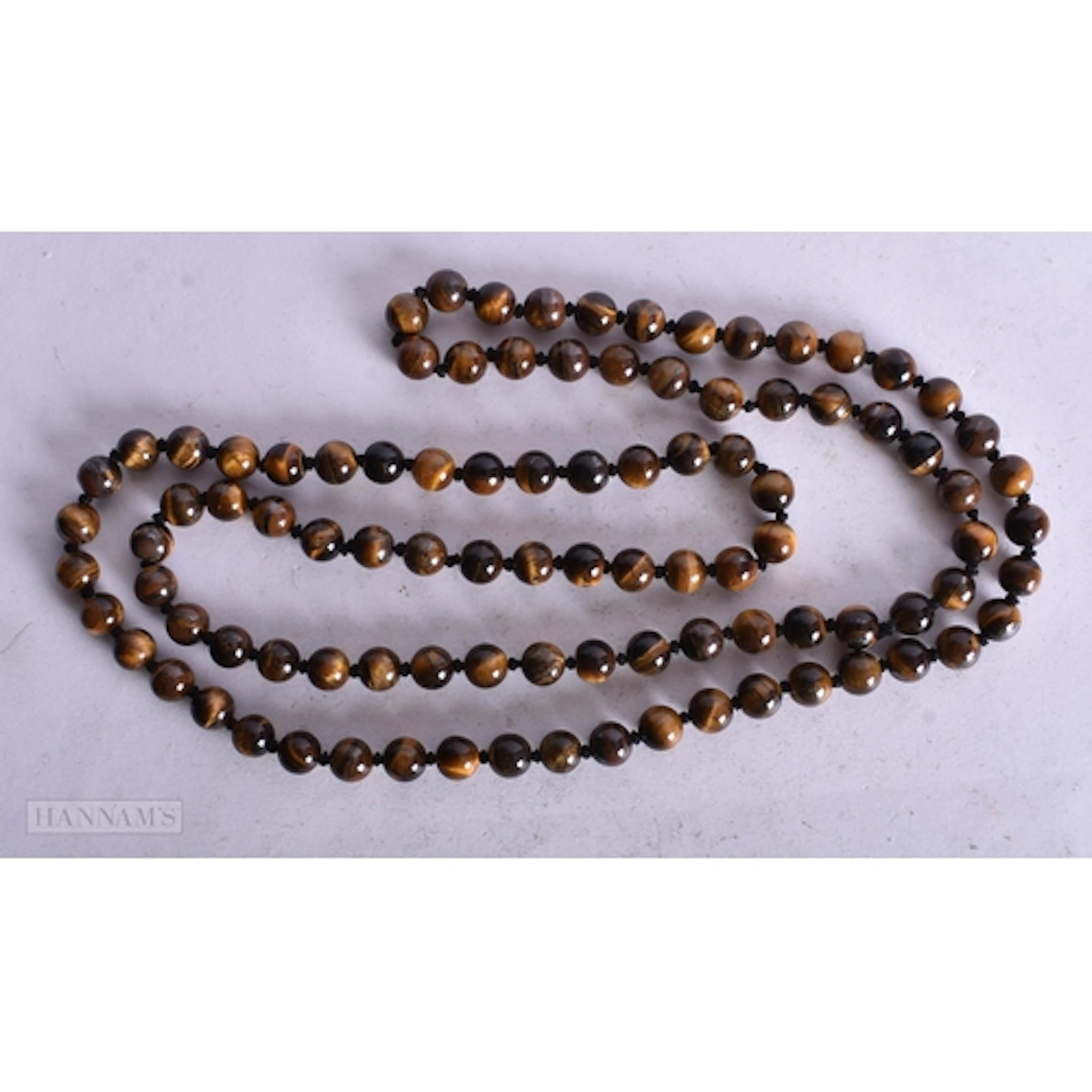 A TIGERS EYE STING BEAD NECKLACE. 98 cm