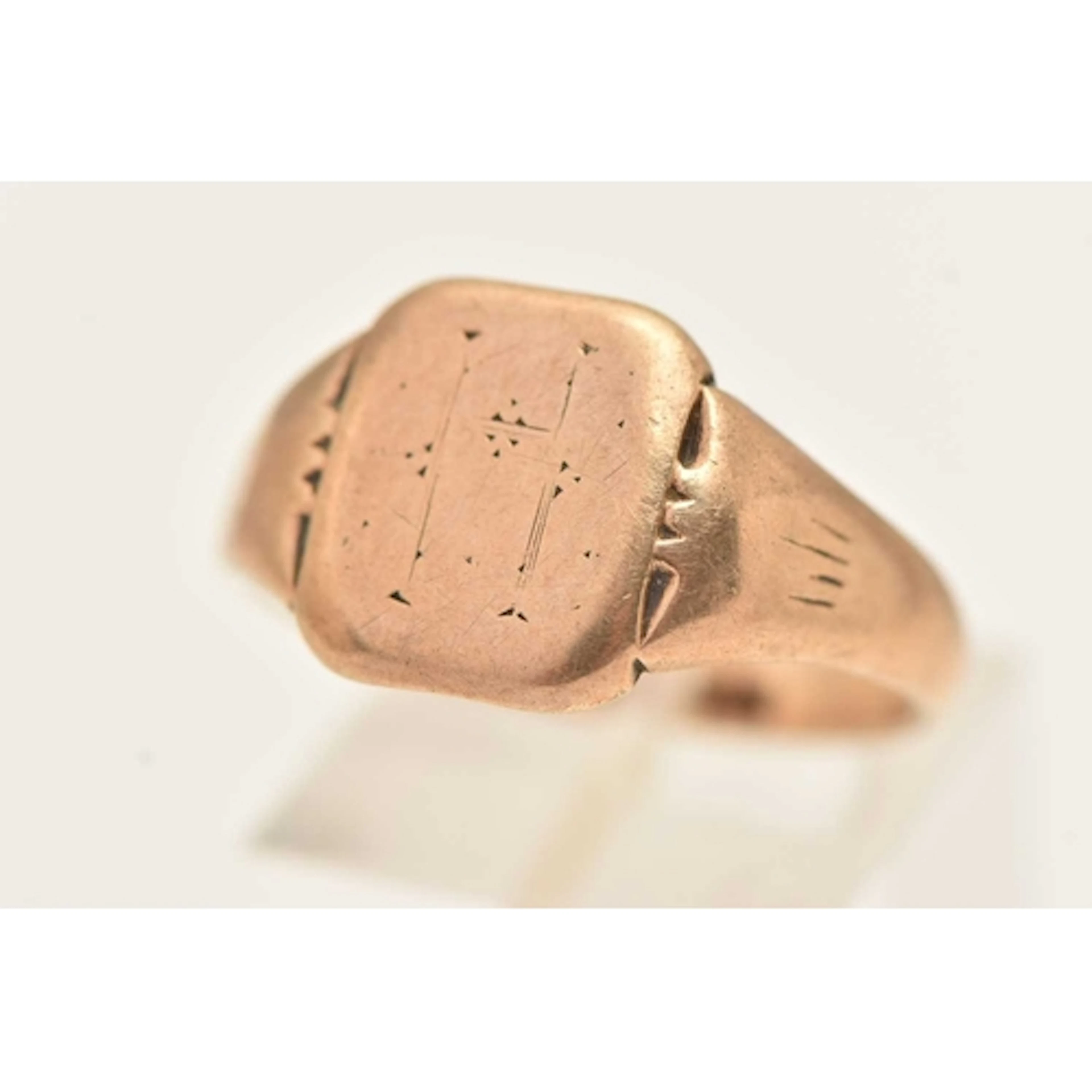A YELLOW METAL SINGET RING, of a square form with worn engra...