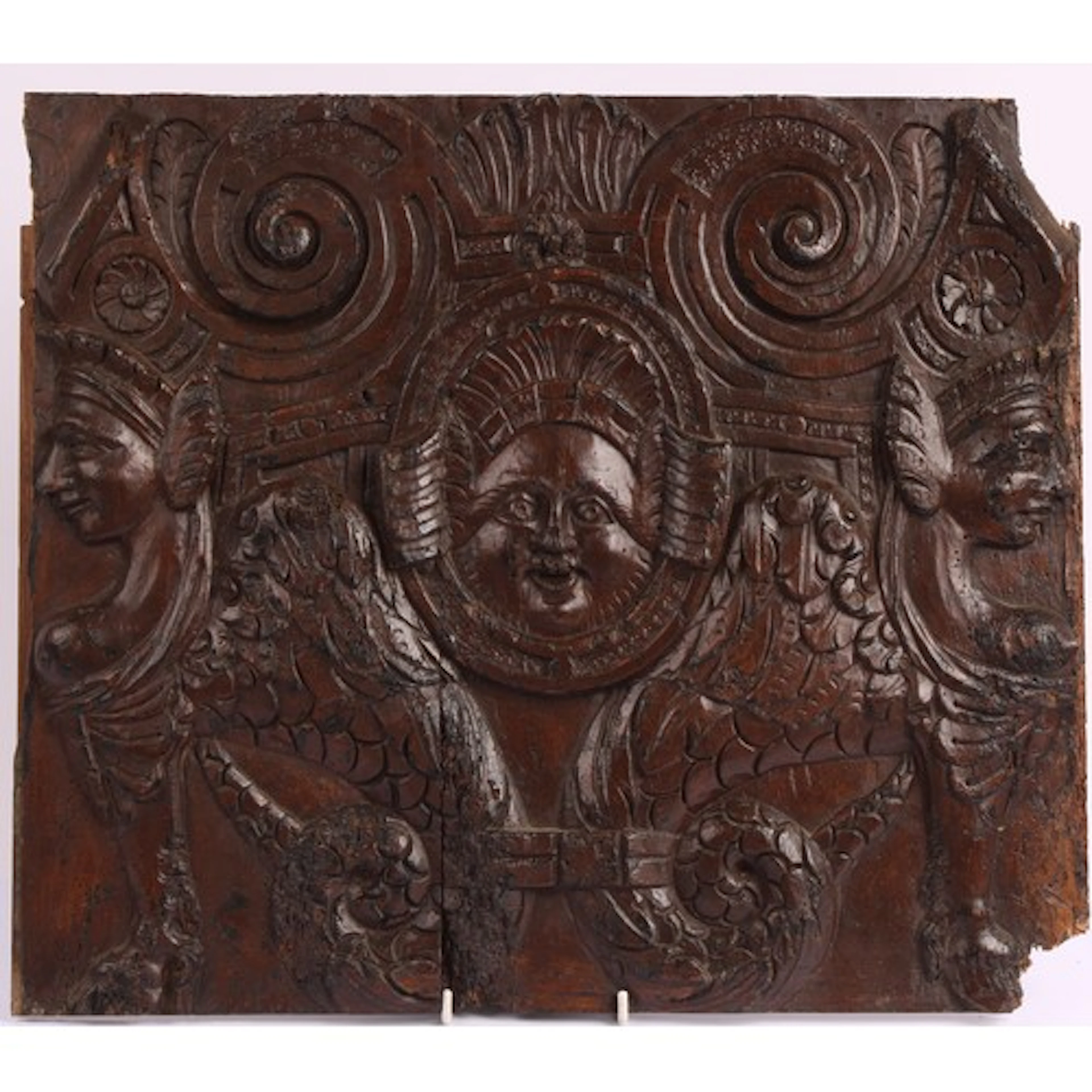 A 16th century style panel, carved with a grotesque mask fla...