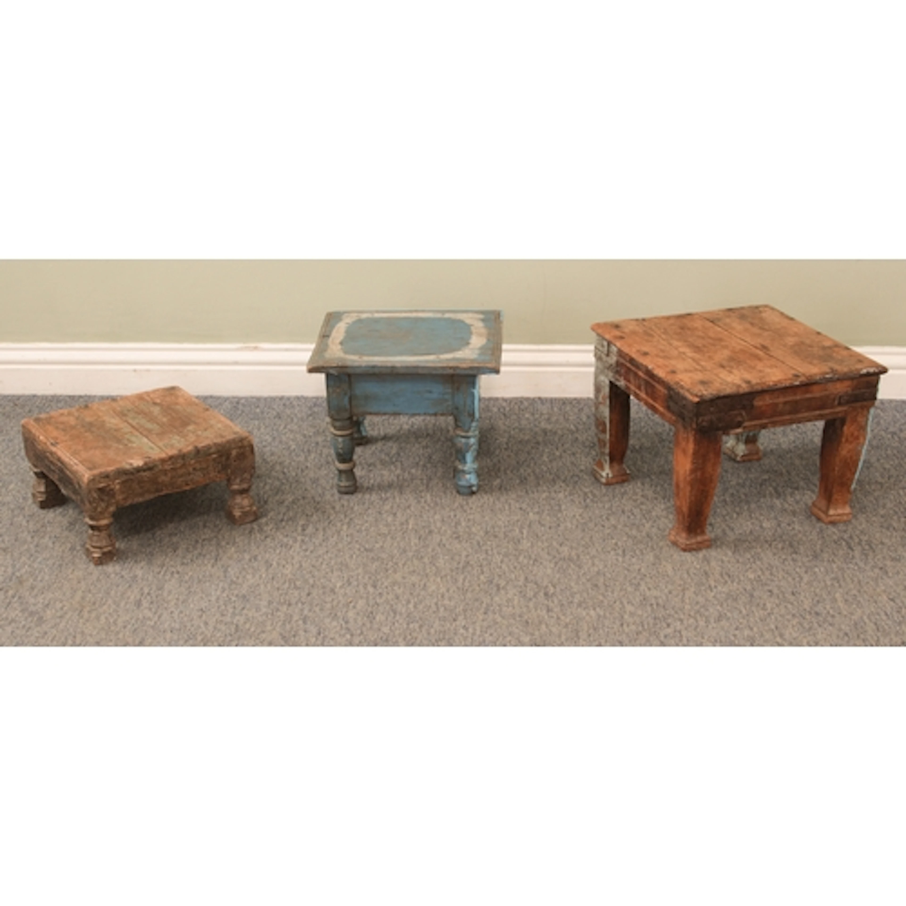 Three Indian teak and painted stools or low occasional table...