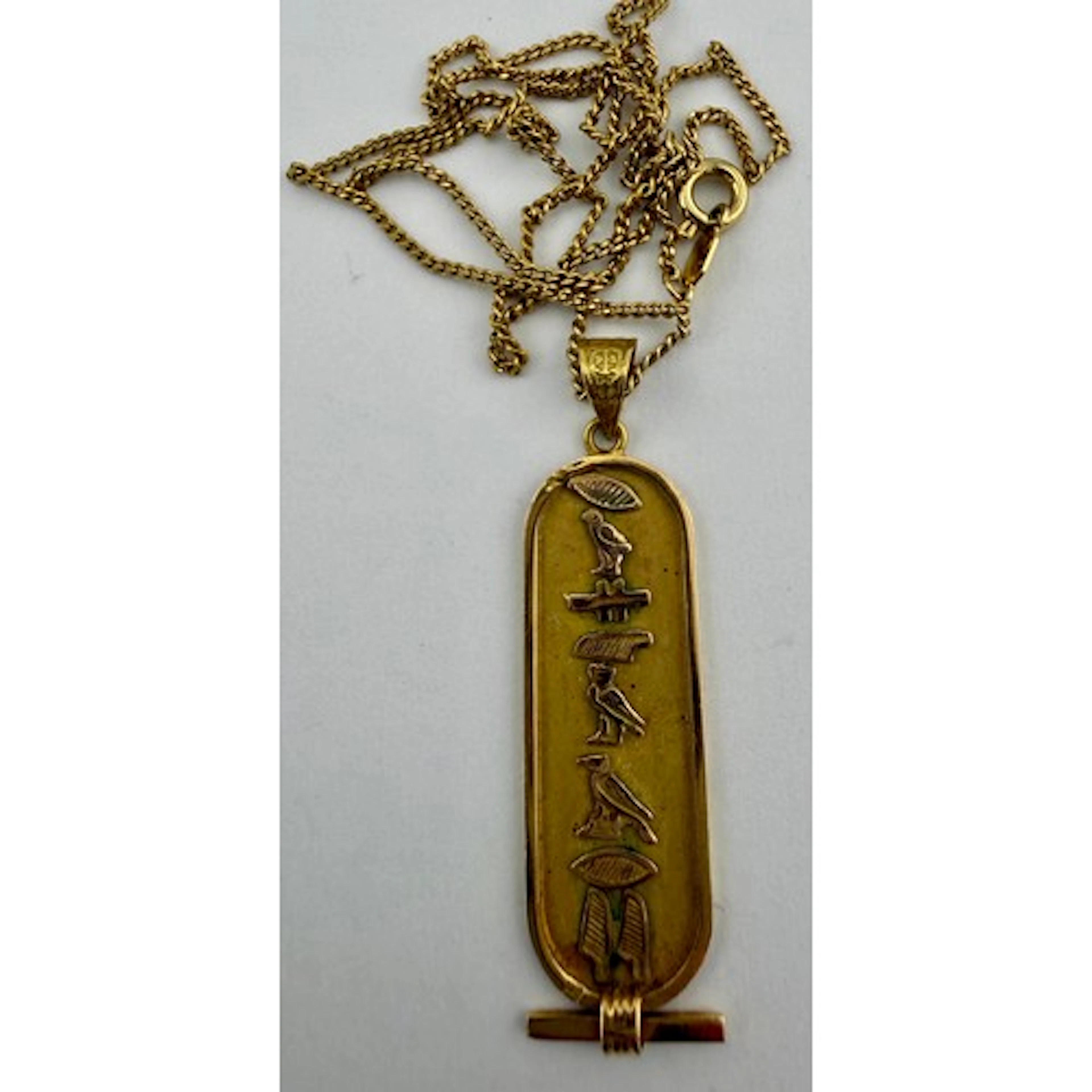Yellow metal Egyptian cartouche pendant on unmarked chain. T...