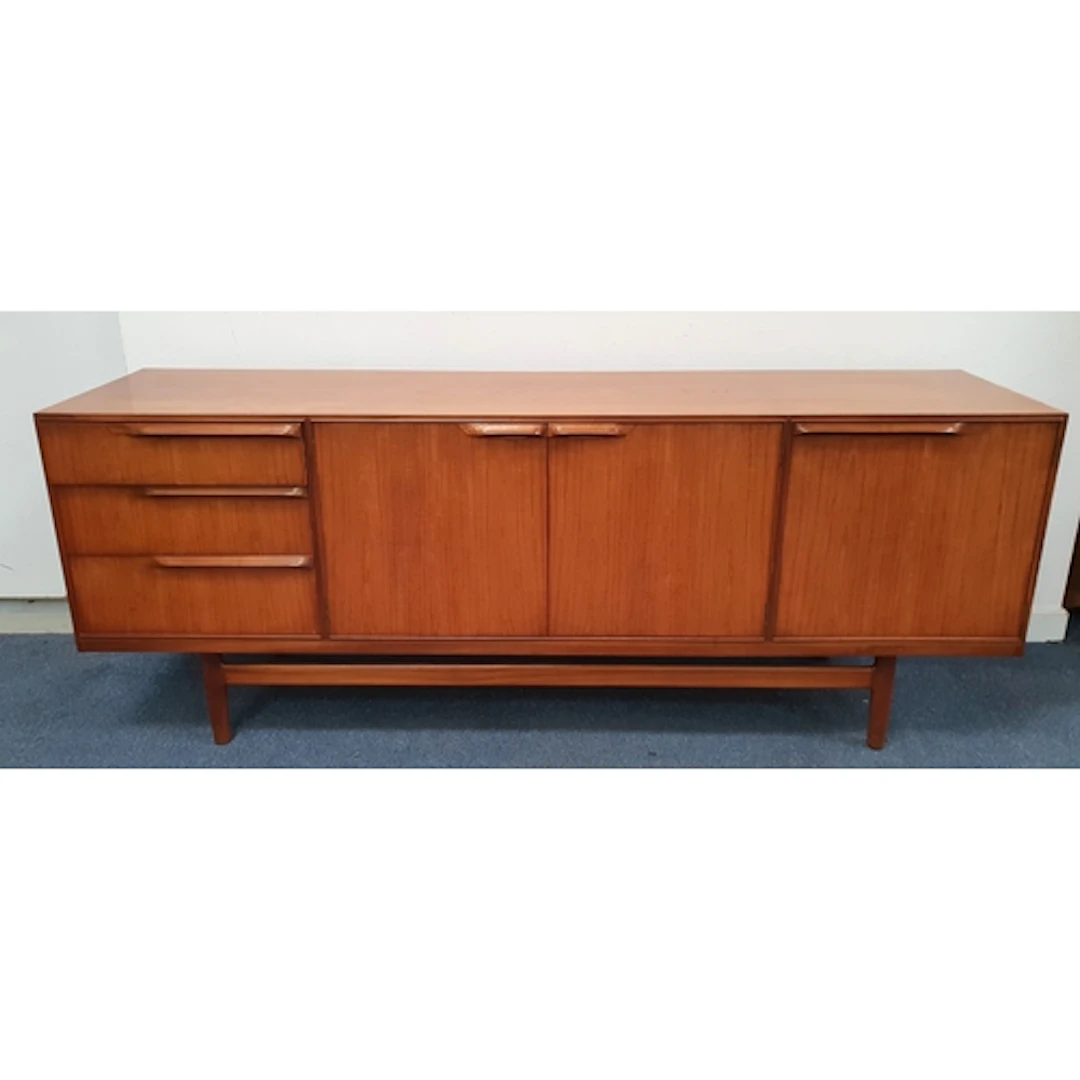 MID-CENTURY TEAK SIDEBOARD with a bank of three graduated dr...
