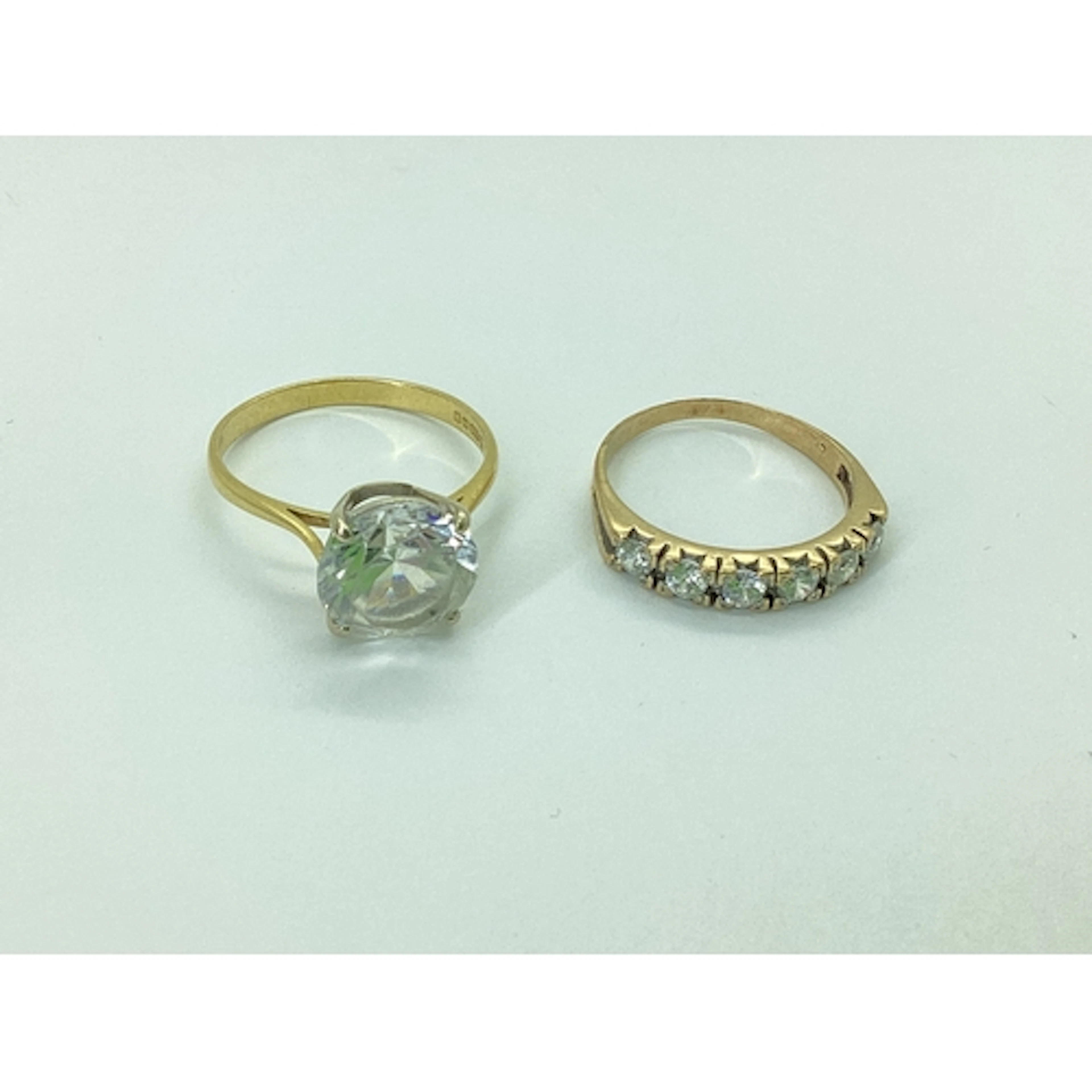 An 18ct Gold CZ Dress Ring, four claw set, between tapered s...