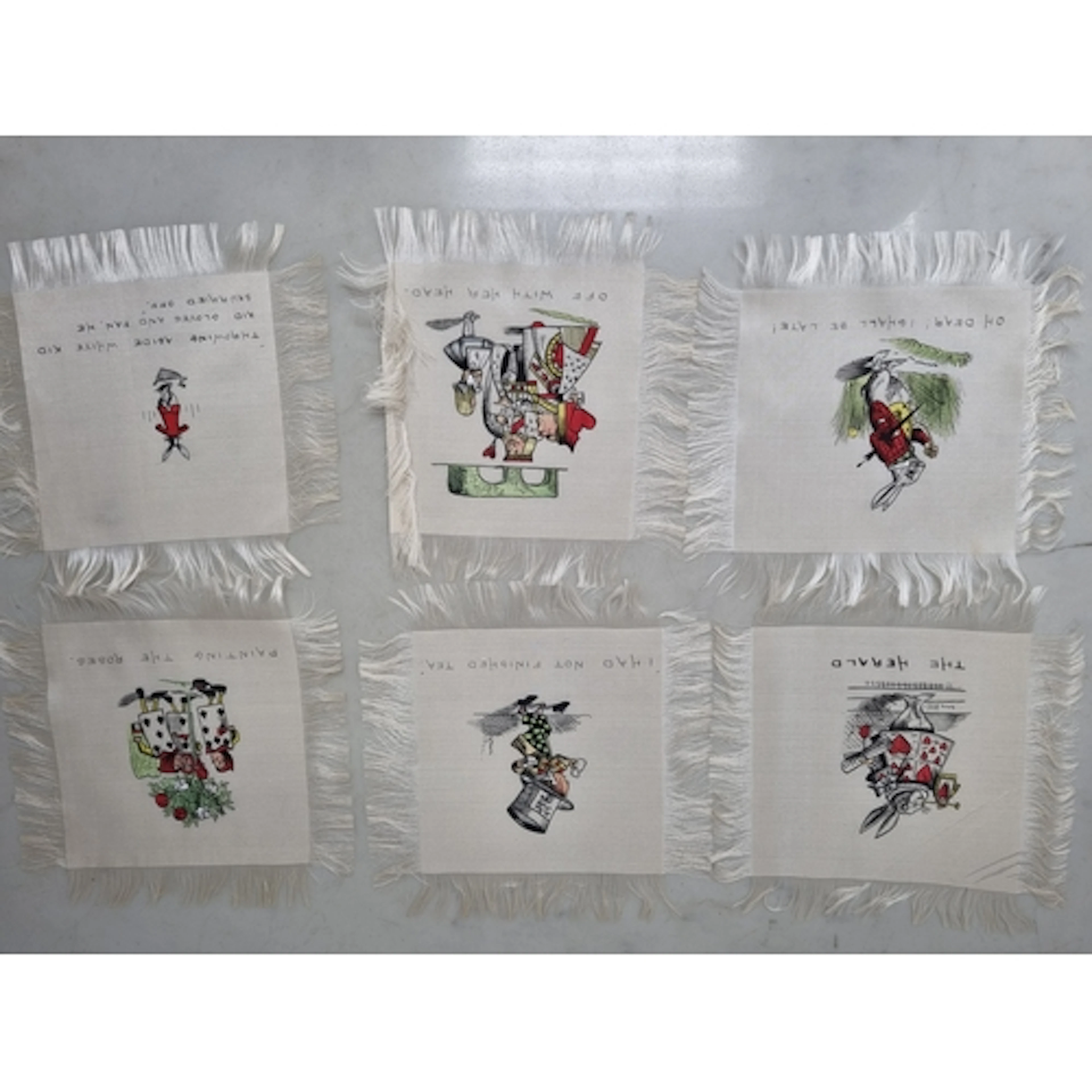 A quantity of silk Place Mats decorated Alice in Wonderland ...
