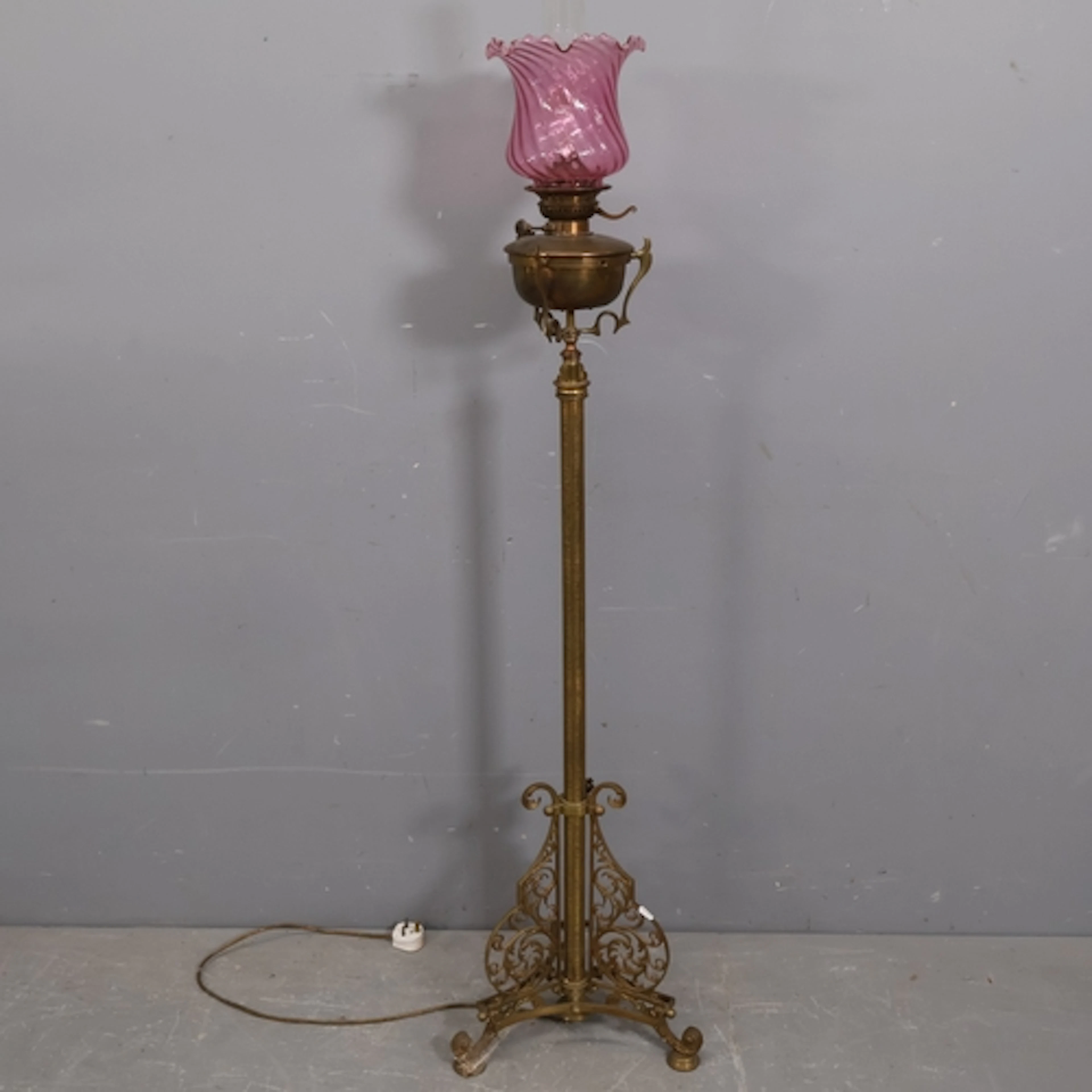 An antique brass floor standing oil lamp, converted to elect...