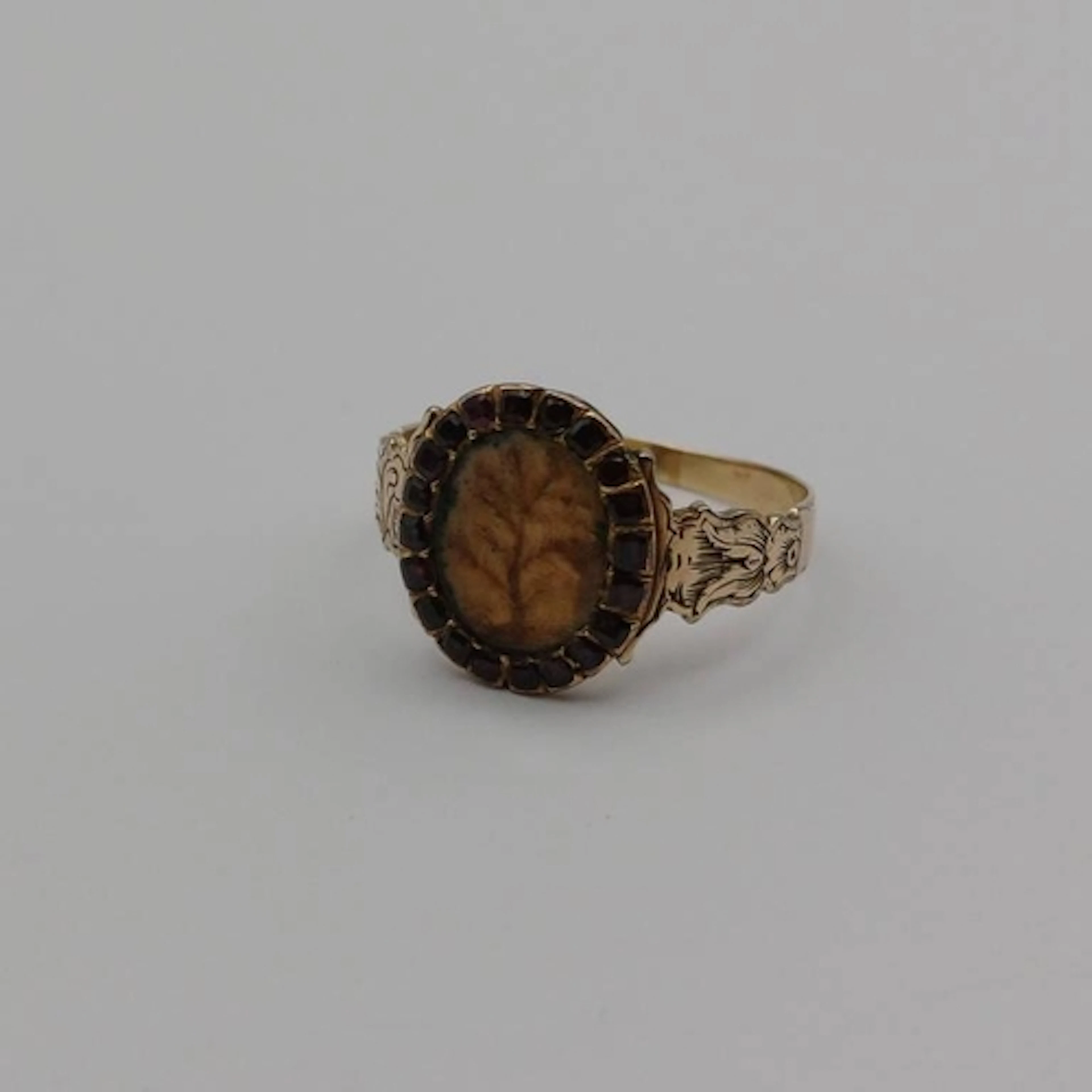19TH CENTURY GARNET SET RING, A GLAZED COMPARTMENT DEPICTING...