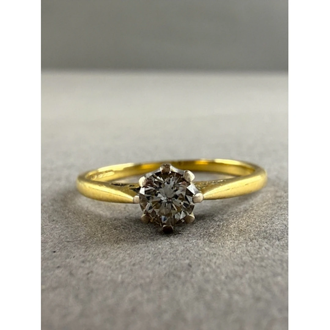 Jewellery: an 18ct yellow gold ring set a solitaire diamond ...