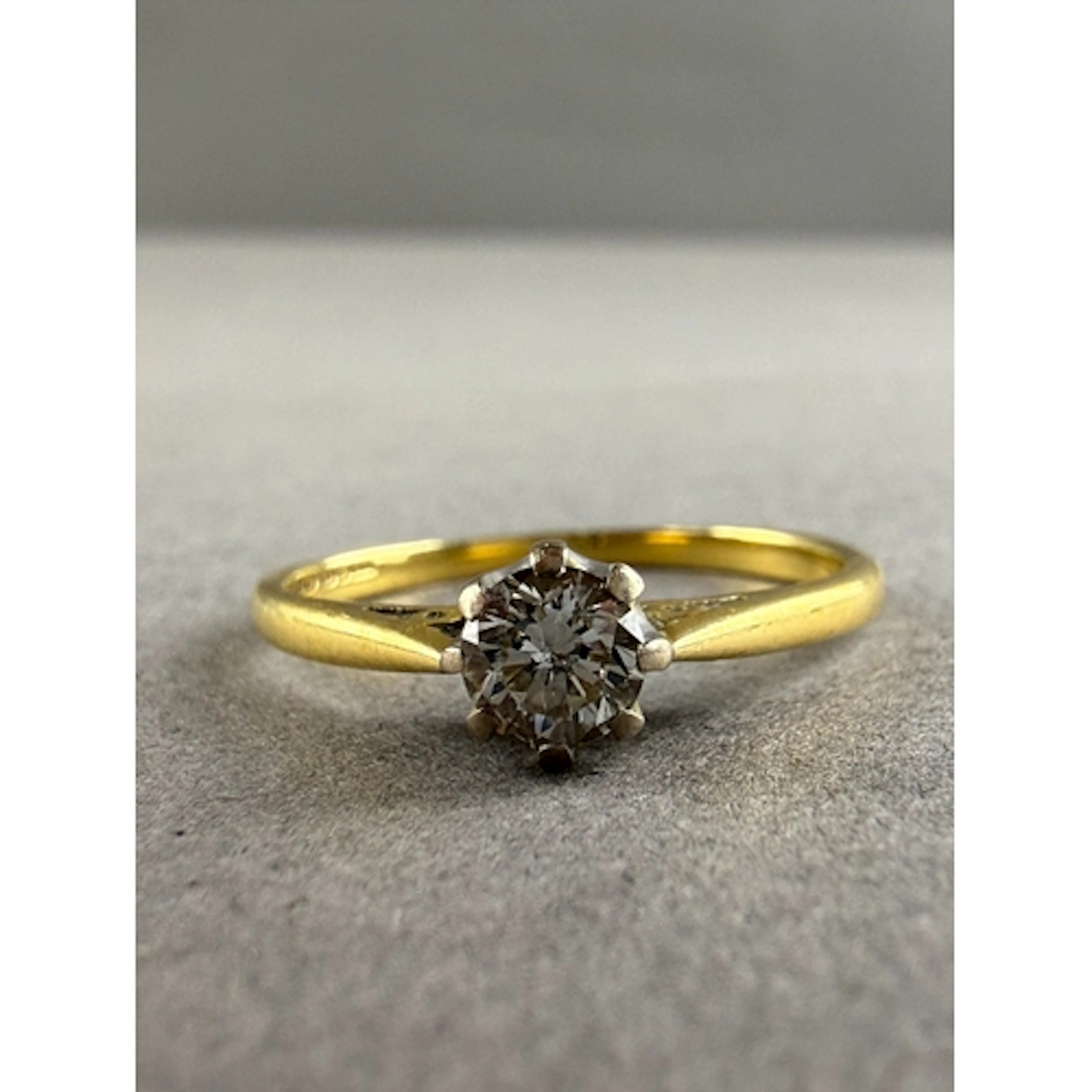 Jewellery: an 18ct yellow gold ring set a solitaire diamond ...