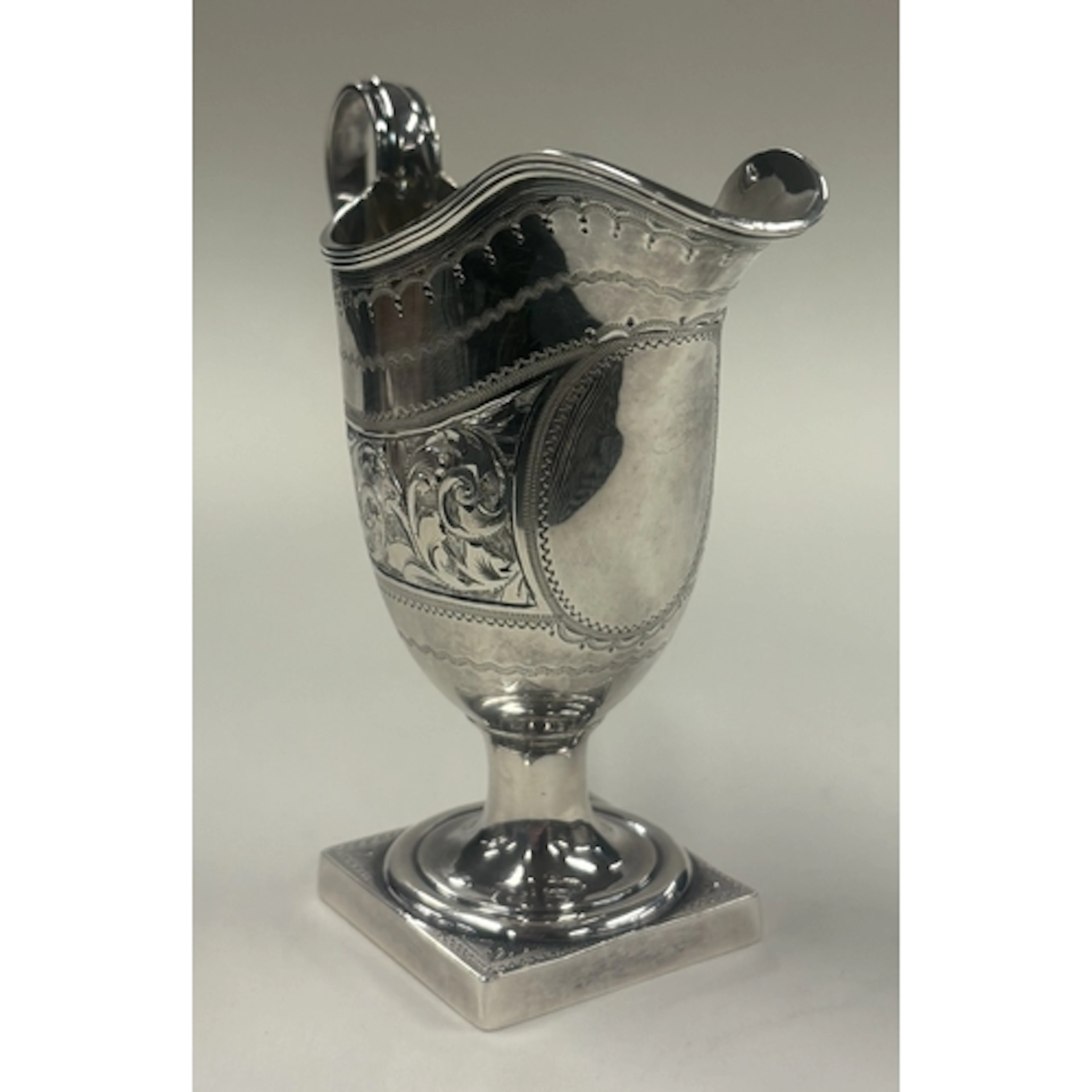 A small Victorian silver cream jug with engraved decoration ...