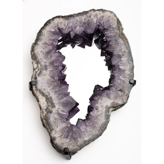 An amethyst quartz geode section fitted as a wall mirror, of...