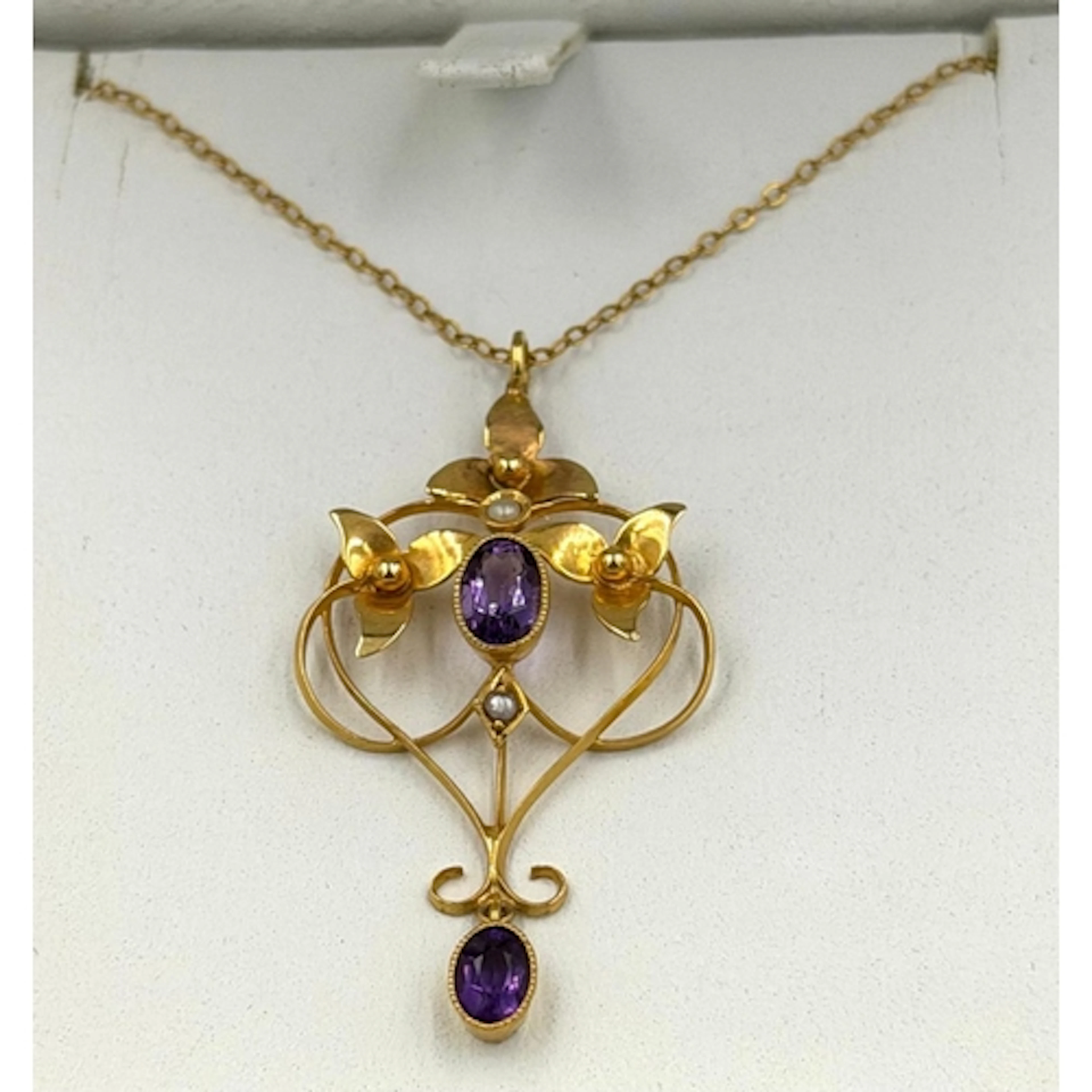 A 9ct gold fine necklace with decorative amethyst and seed p...
