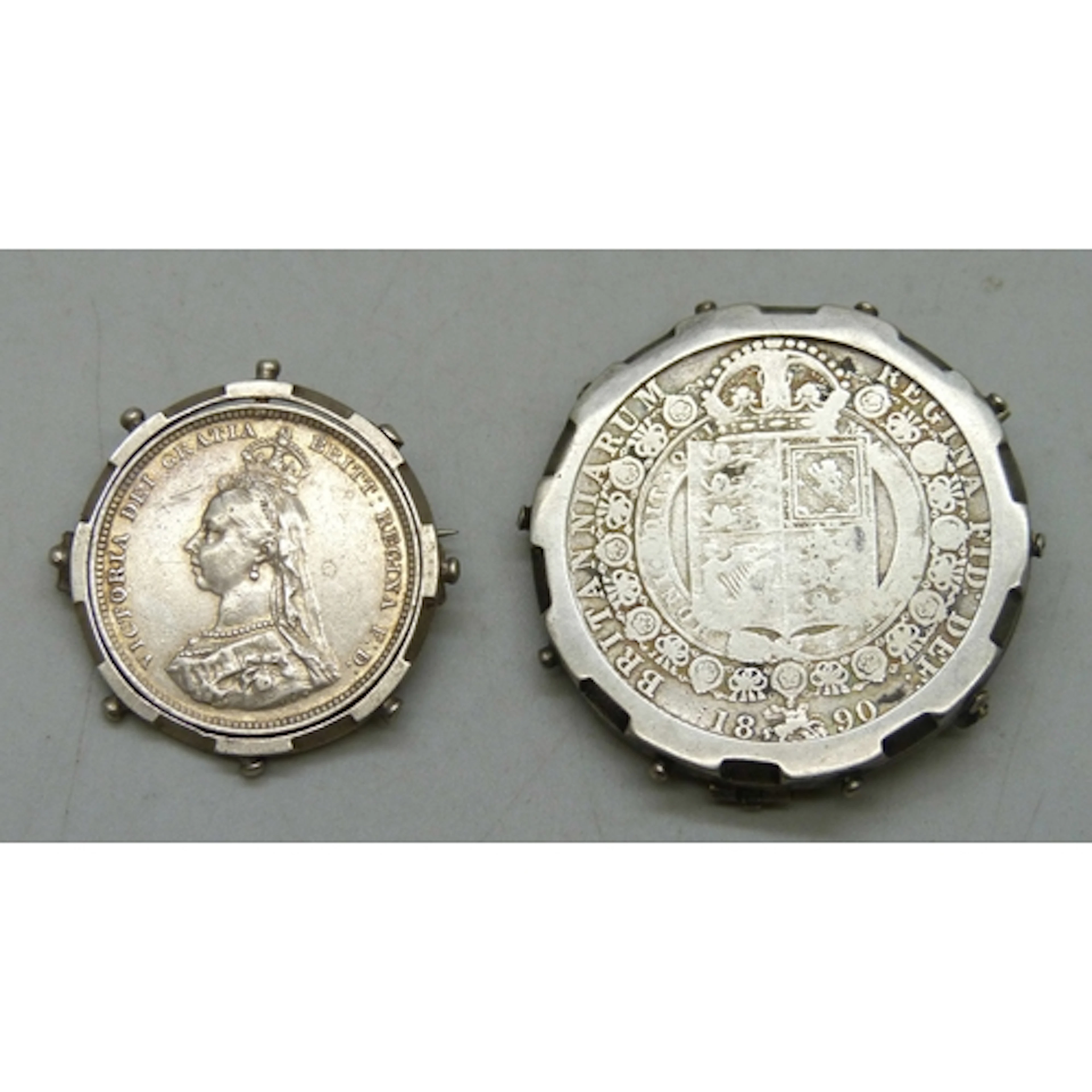 A Victorian 1887 silver mounted coin, and an 1890 white meta...