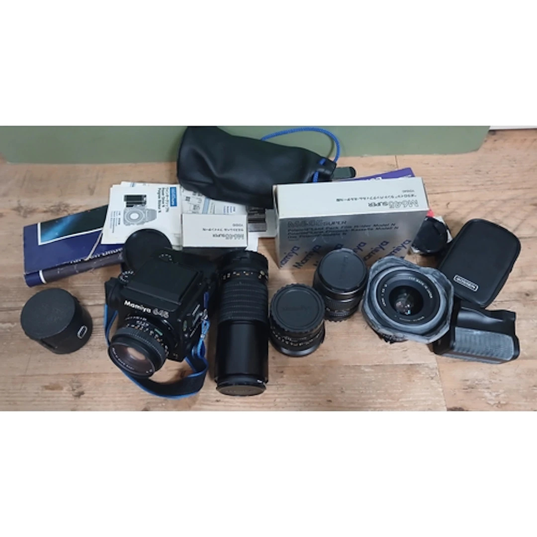 A Mamiya 645 medium format camera with five lenses and and a...