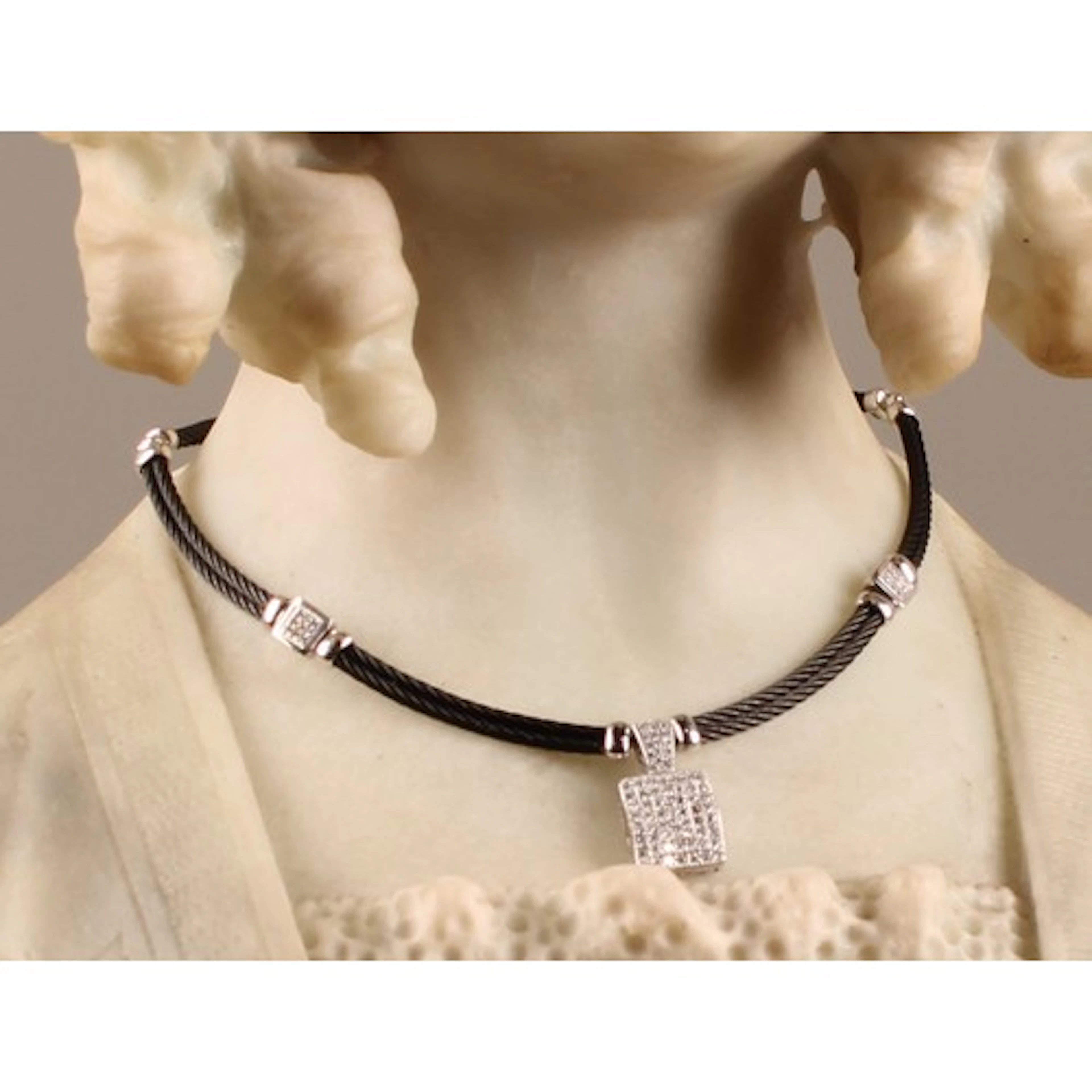 An unmarked white metal diamond accented cable choker or Chi...