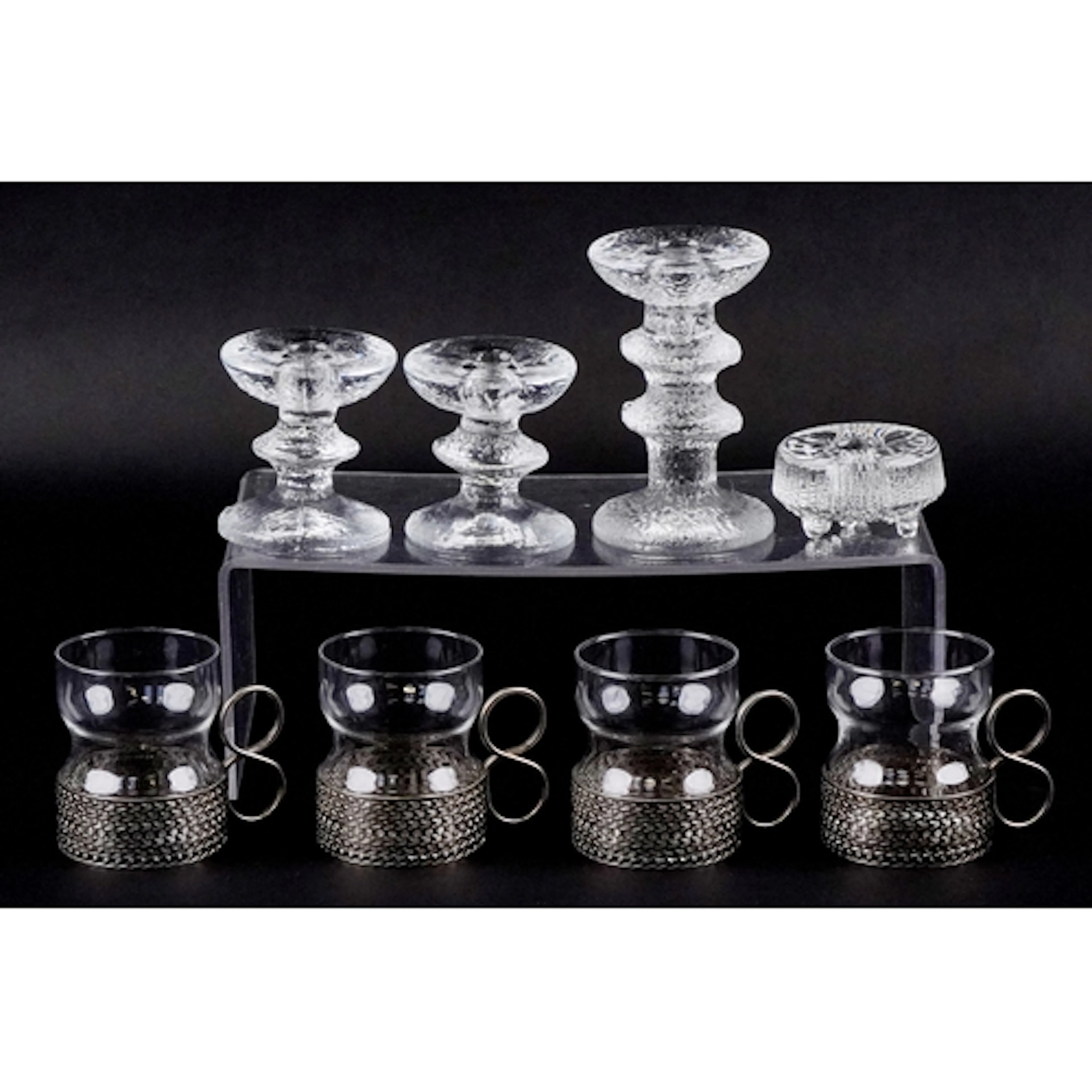 Four Finnish glass candlesticks and a set of four designer g...